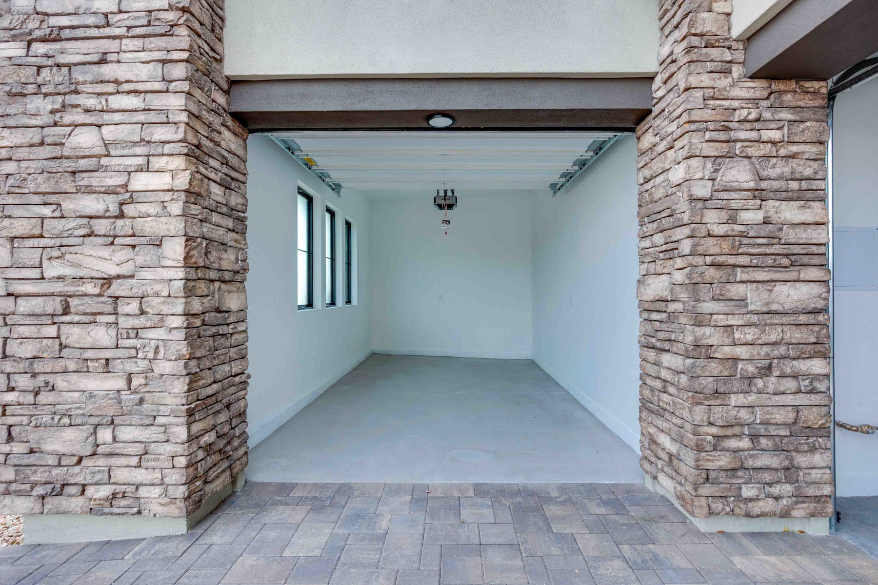 A spacious entryway with stone walls and a tiled floor, leading to a bright and open interior space.