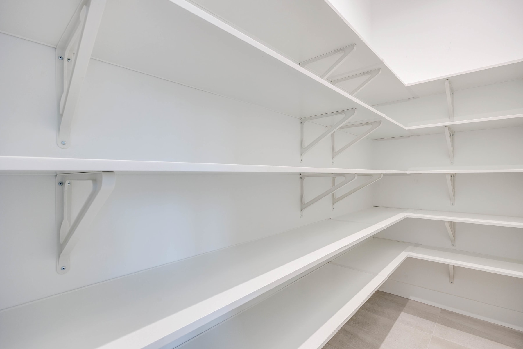 The image depicts a well-organized and spacious walk-in closet with multiple shelves and storage spaces, providing ample room for storage and organization.