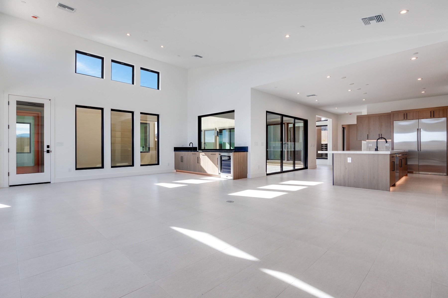 A spacious, modern interior with large windows, a kitchen area, and a clean, minimalist design.
