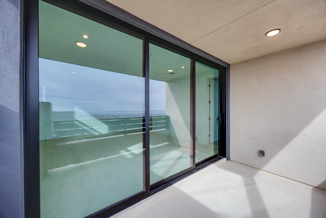 The image shows a modern interior with large glass windows overlooking a scenic outdoor landscape.