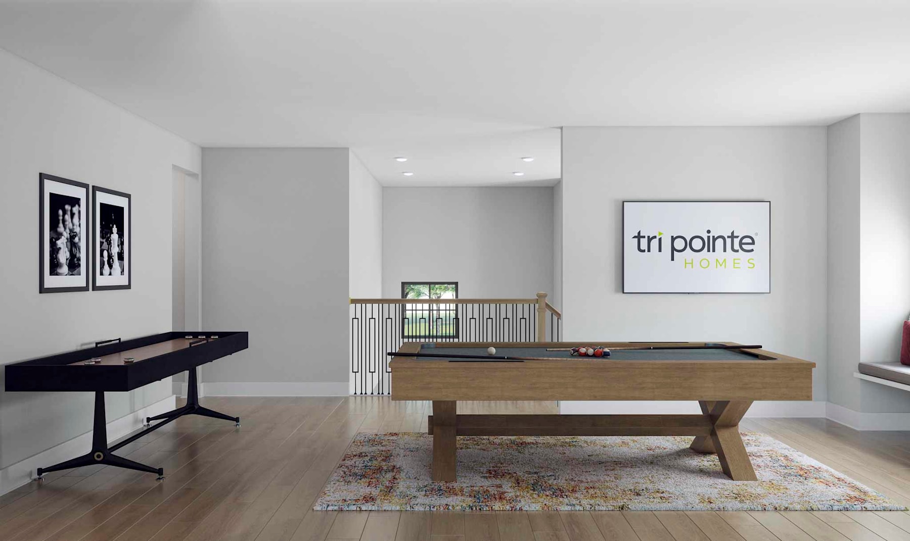 A modern and minimalist office space with a pool table, framed artwork, and a large sign displaying the company name "Tri Pointe".