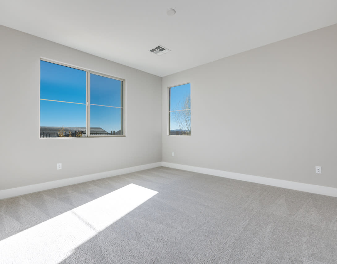 An empty, bright room with large windows overlooking a scenic outdoor view.