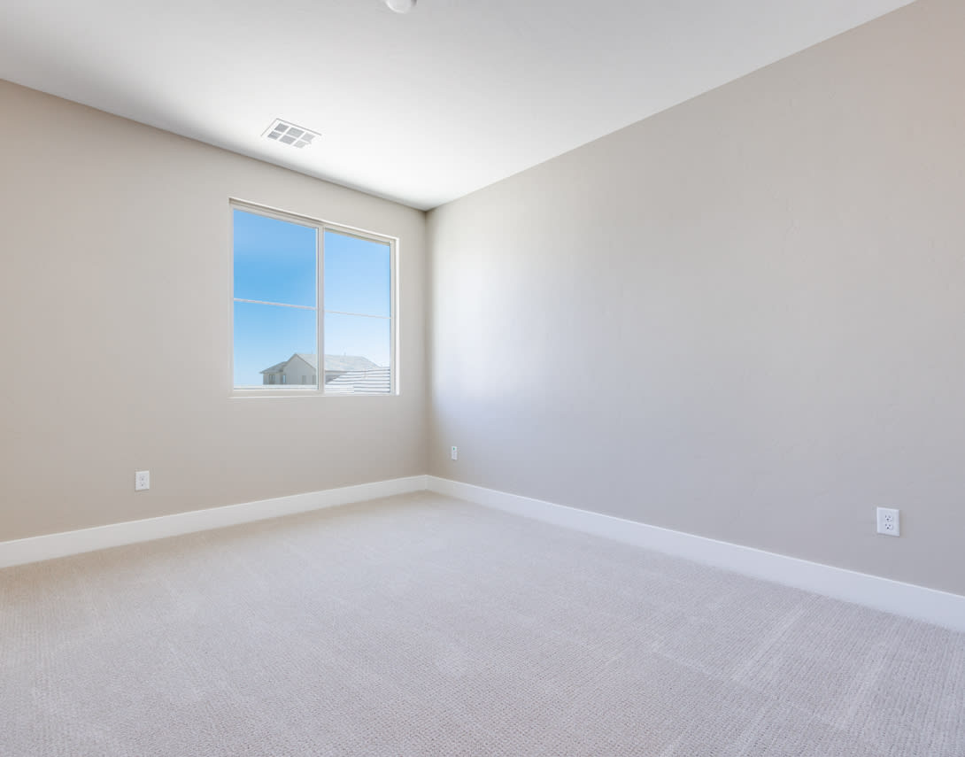 A spacious, empty room with a large window overlooking the sky, featuring a clean, minimalist design.