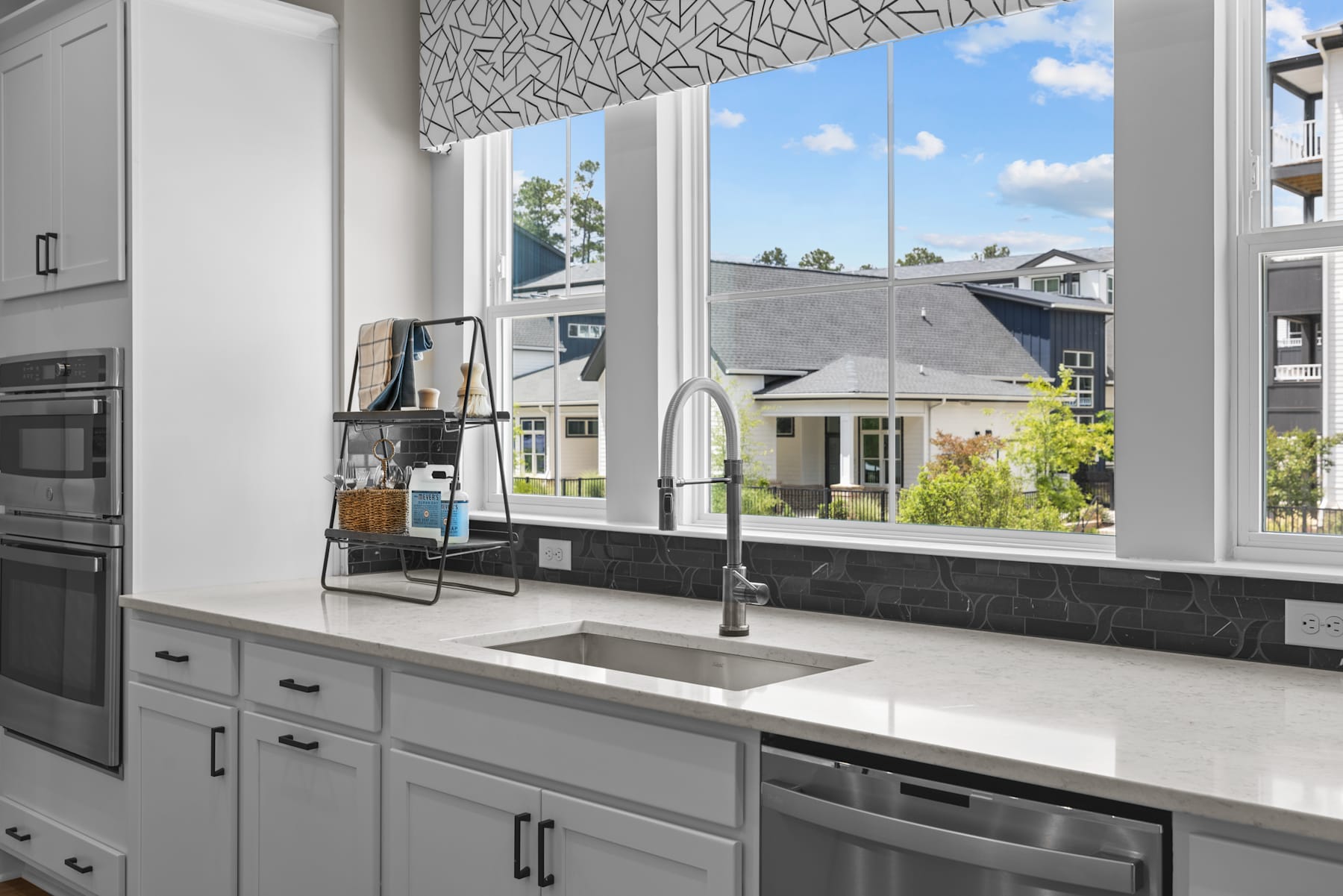 A modern, well-equipped kitchen with a large window overlooking a scenic outdoor landscape.