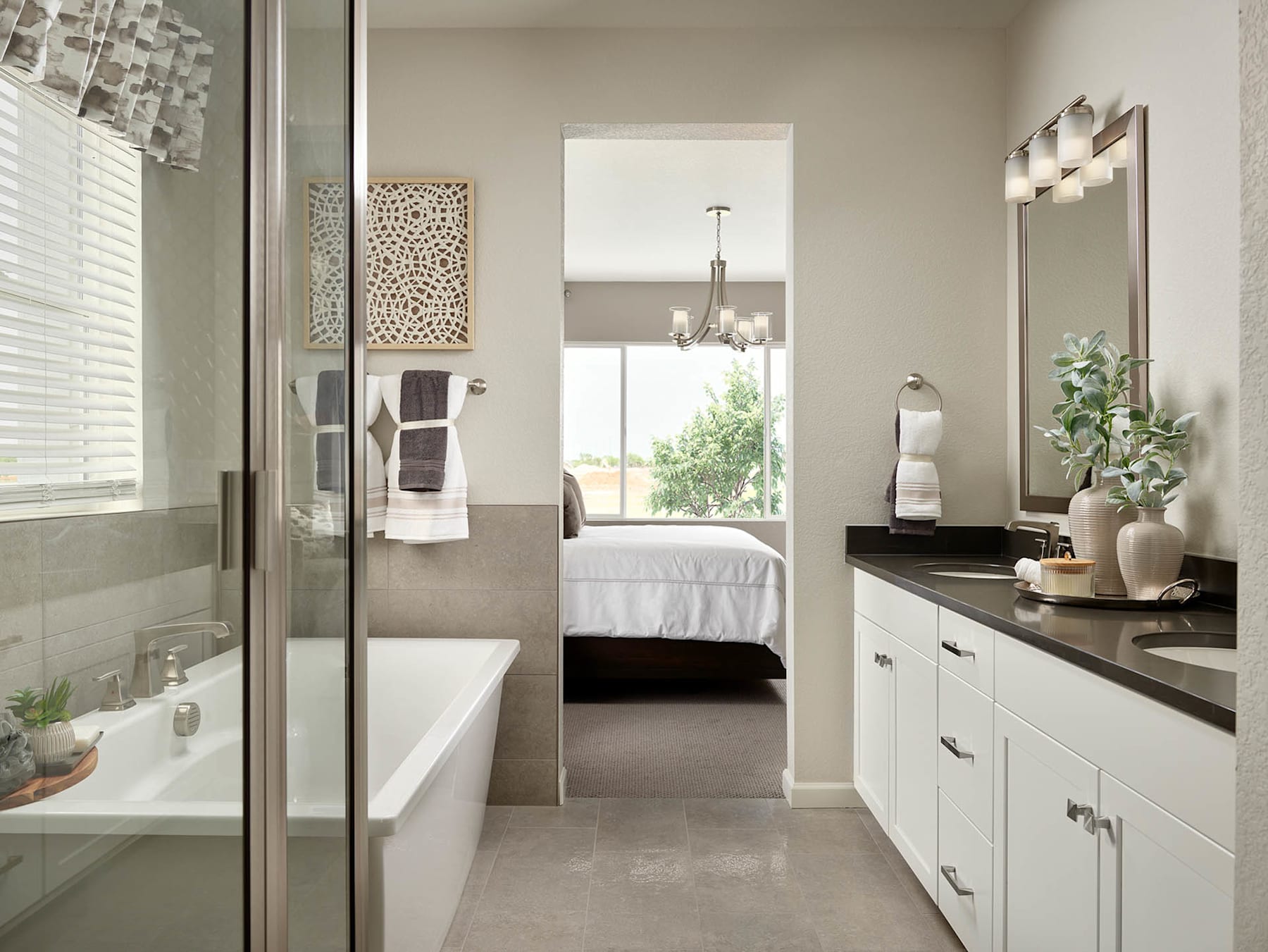 A modern and minimalist bathroom with a sleek vanity, a large mirror, and a view of the adjacent bedroom through an open doorway.