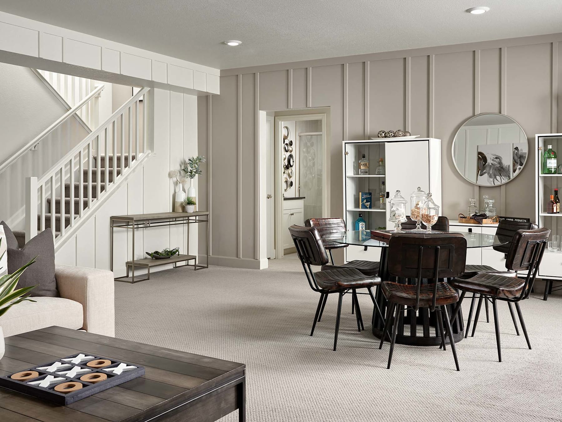 A cozy and inviting open-concept living space with a dining area, featuring neutral-toned walls, wooden furniture, and various decorative elements.