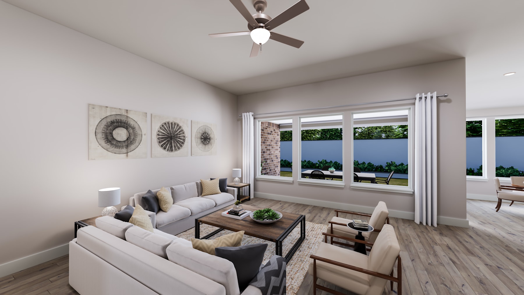 A cozy and modern living room with a large window overlooking a scenic outdoor view, featuring a comfortable sofa arrangement, decorative wall art, and a ceiling fan.