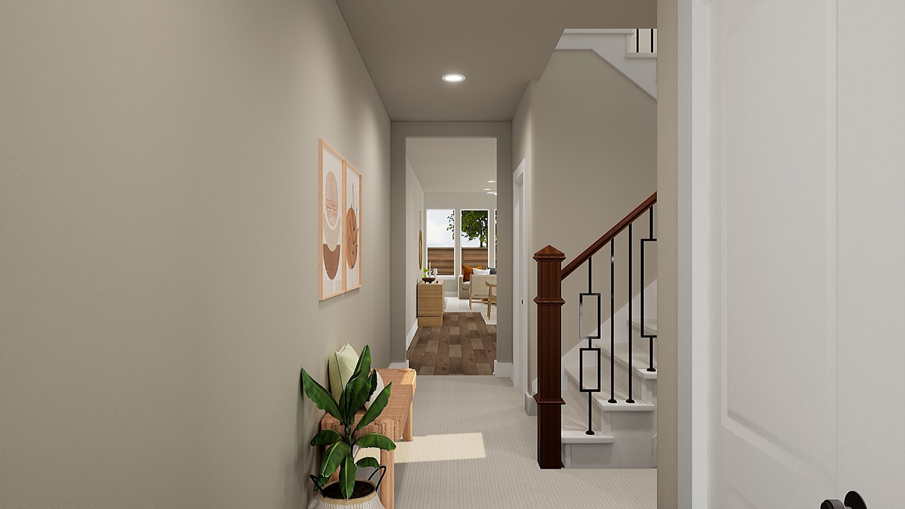 A well-lit hallway with a wooden staircase, potted plant, and artwork on the walls, leading to a room in the background.