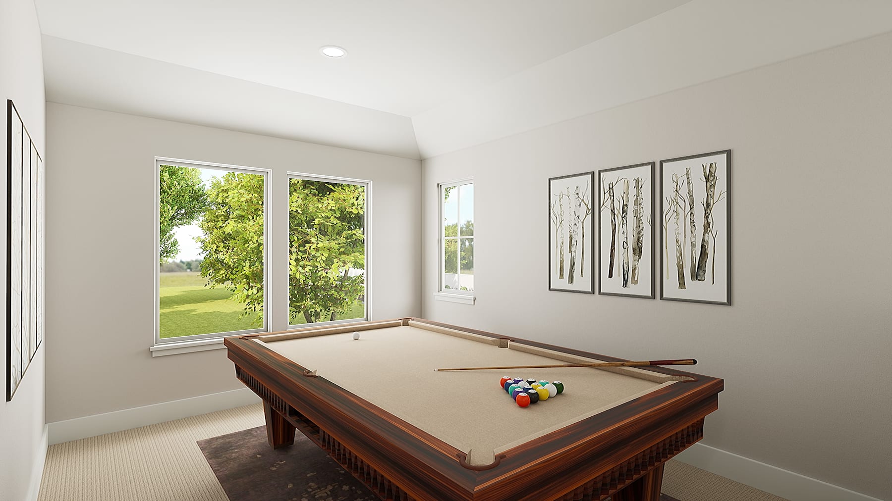 A spacious room with a large window overlooking a lush green outdoor area, featuring a wooden pool table in the foreground and framed artwork on the walls.