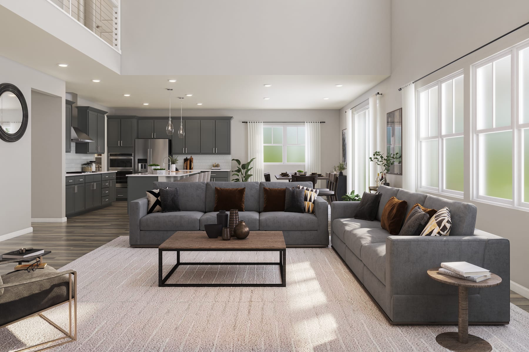A spacious and modern living room with a large gray sectional sofa, a wooden coffee table, and a kitchen visible in the background with dark cabinets and stainless steel appliances.