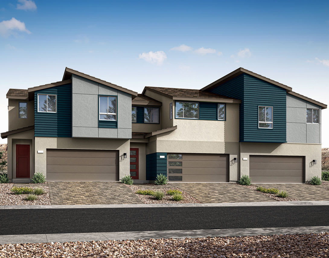 The image depicts a row of modern, two-story townhouses with a mix of gray, blue, and beige siding. The homes have attached garages and are situated on a paved driveway, with a gravel-covered yard in the foreground.