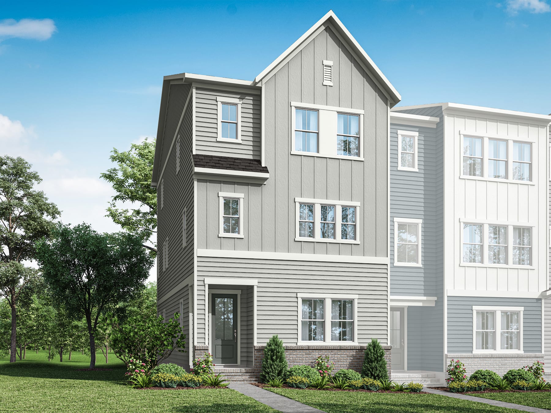 A modern, multi-story residential building with gray siding and white trim, surrounded by lush greenery and a clear blue sky.