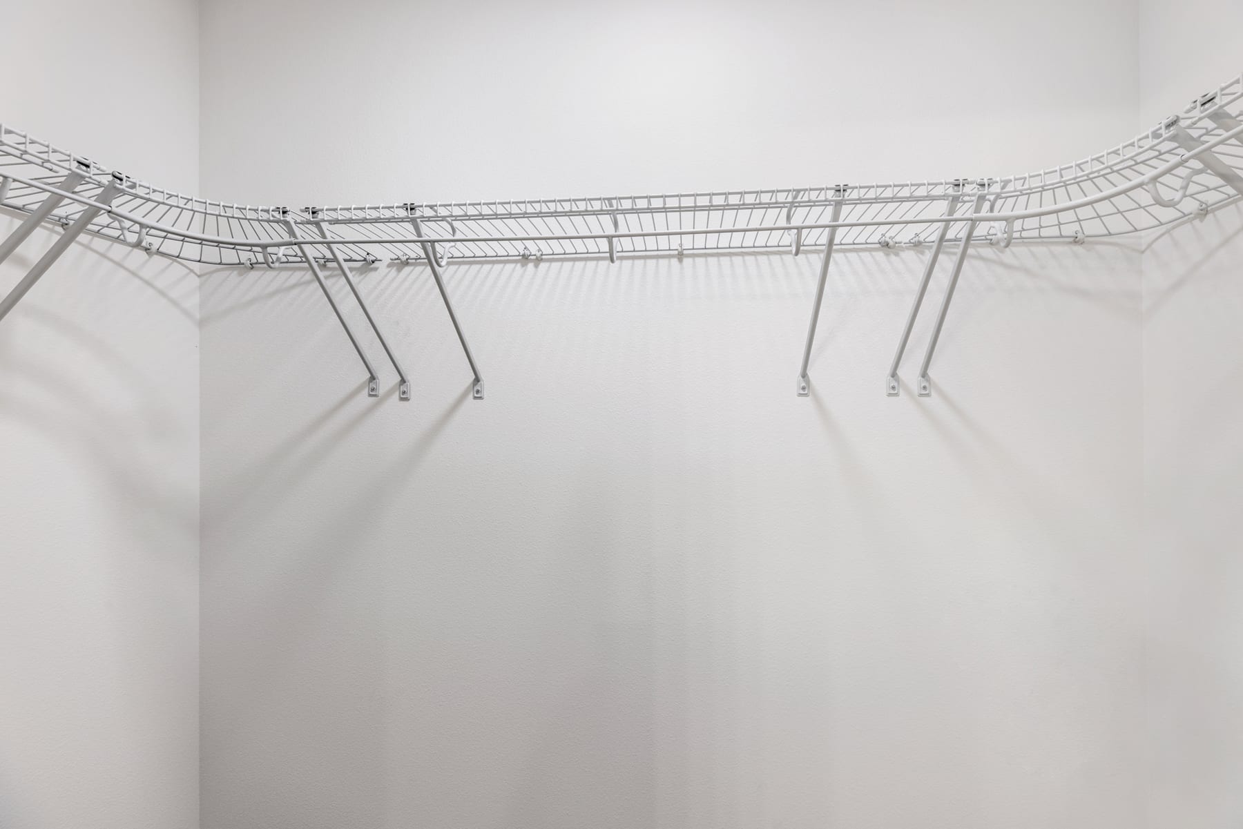A minimalist wire sculpture suspended in a hazy, white space, creating an ethereal and abstract visual effect.