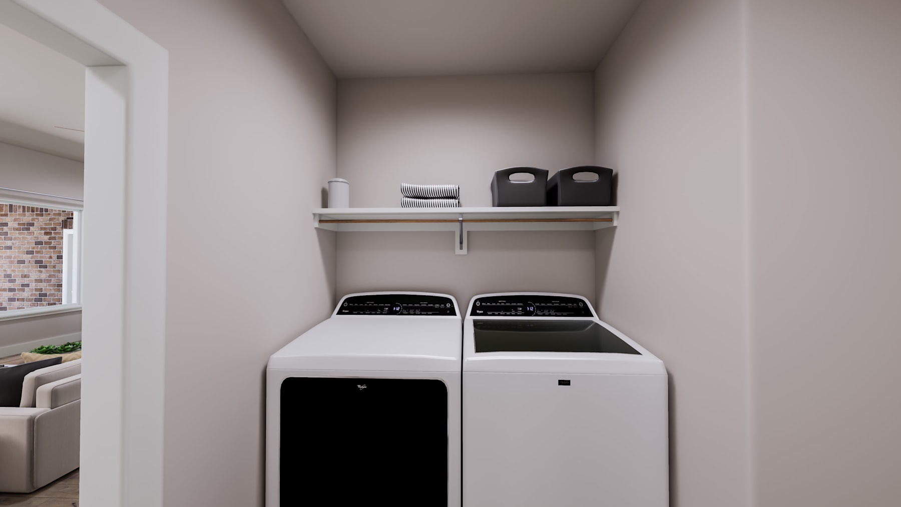 A modern, minimalist laundry room with a white washer and dryer set against a neutral-colored wall, featuring shelving above for storage.