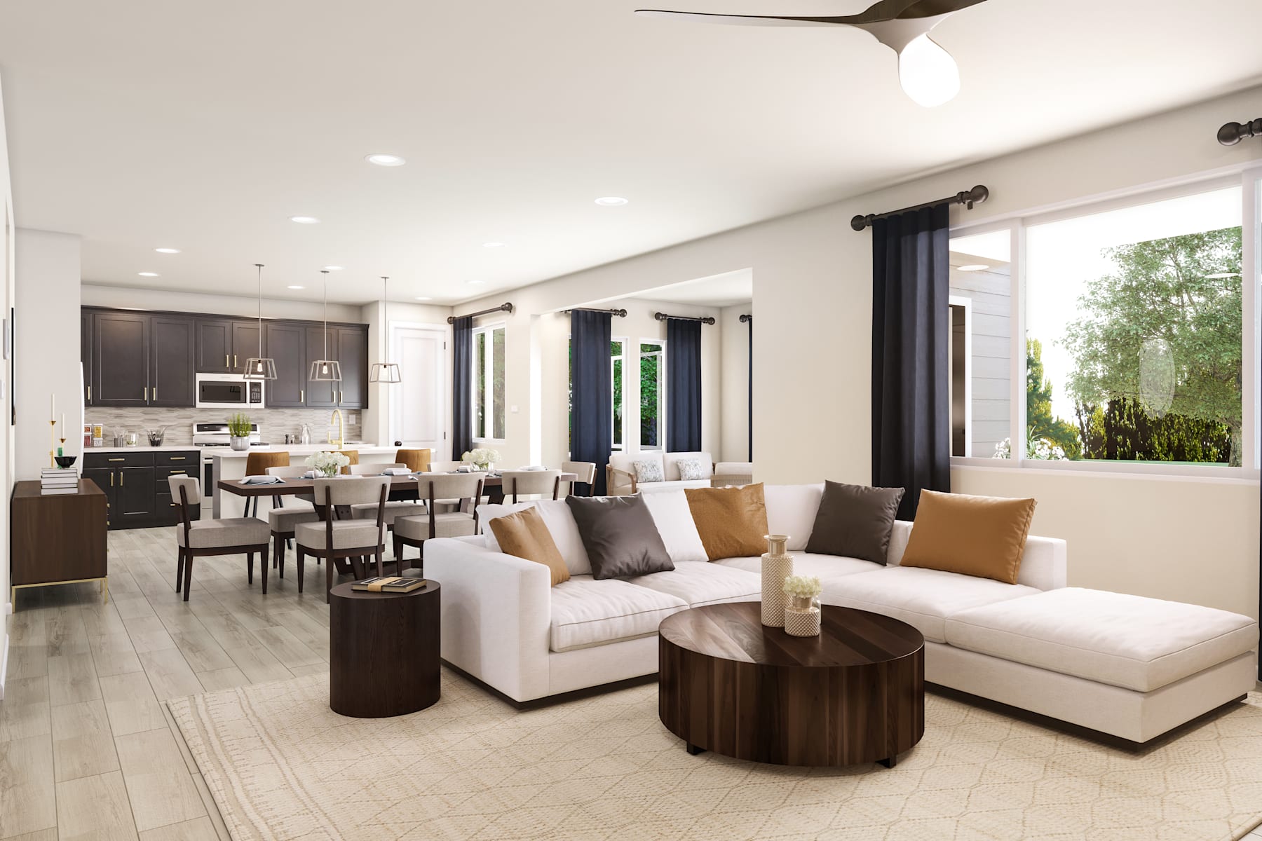 A modern and spacious open-concept living room with a white sectional sofa, wooden coffee tables, and a dining area with a table and chairs, all set against a backdrop of large windows overlooking a lush outdoor environment.