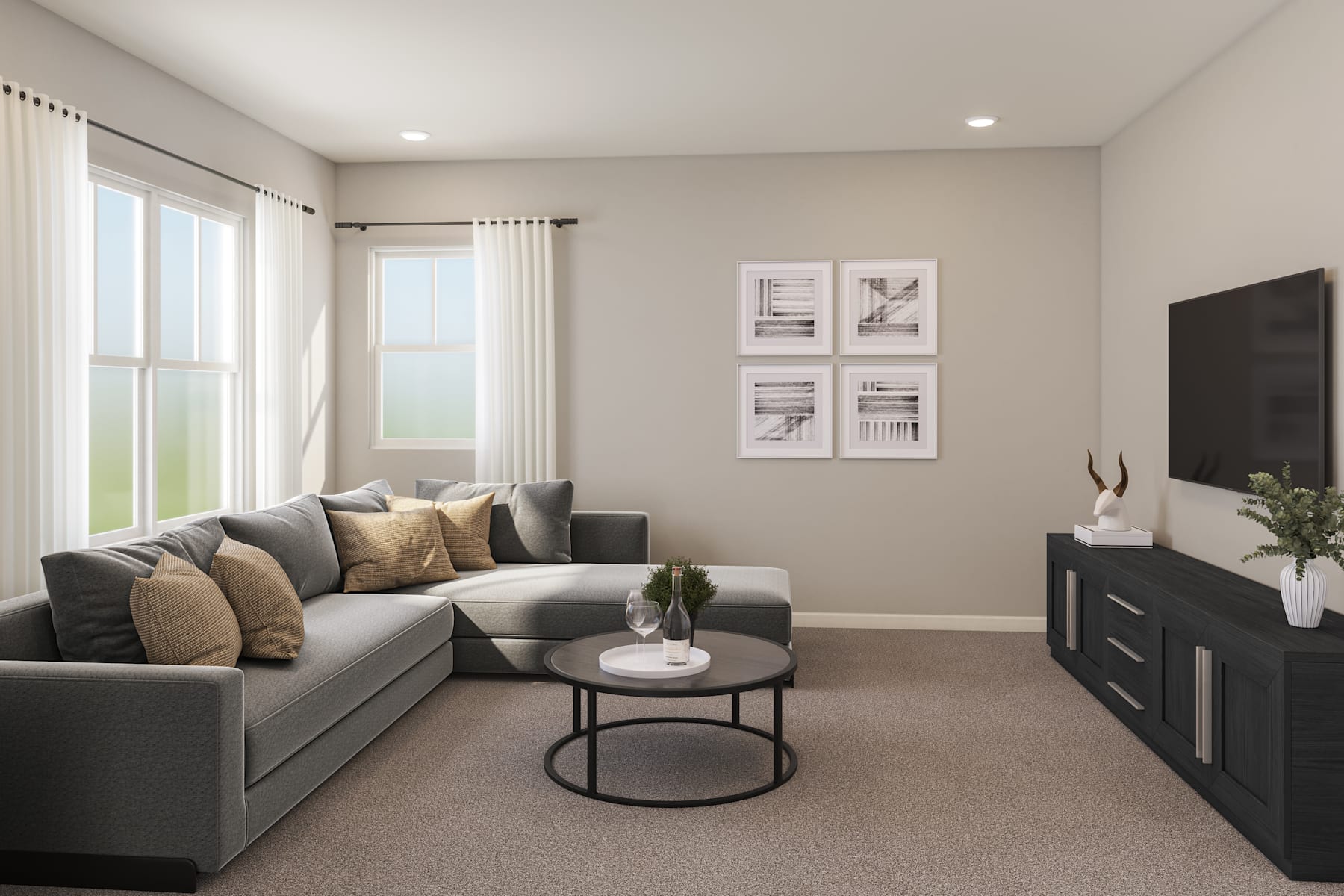 A cozy living room with a gray sectional sofa, a round coffee table, and framed artwork on the walls, set against a neutral color scheme and large windows providing natural light.