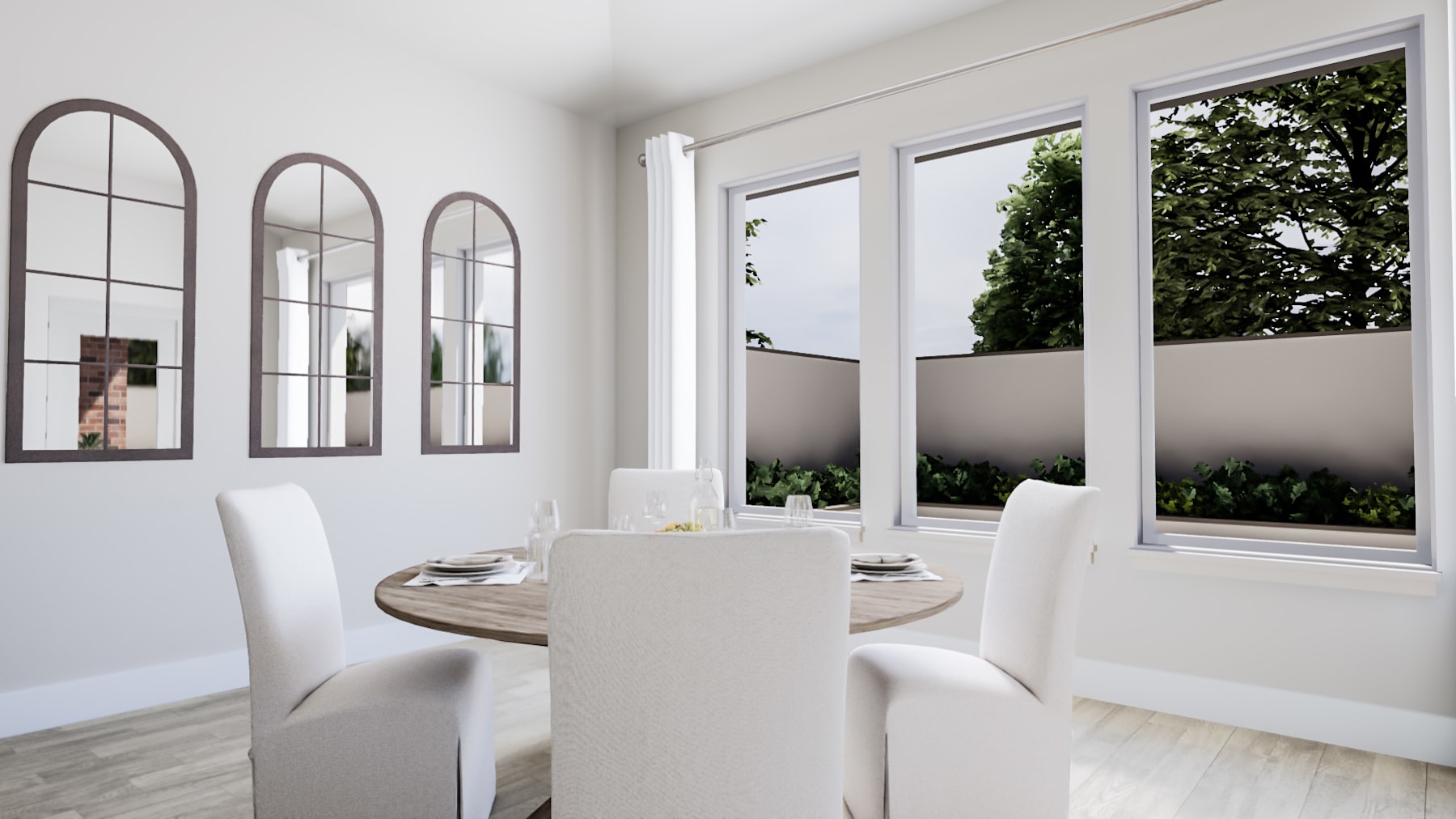 A modern and minimalist dining room with a round wooden table, white chairs, and large arched windows overlooking a lush outdoor landscape.