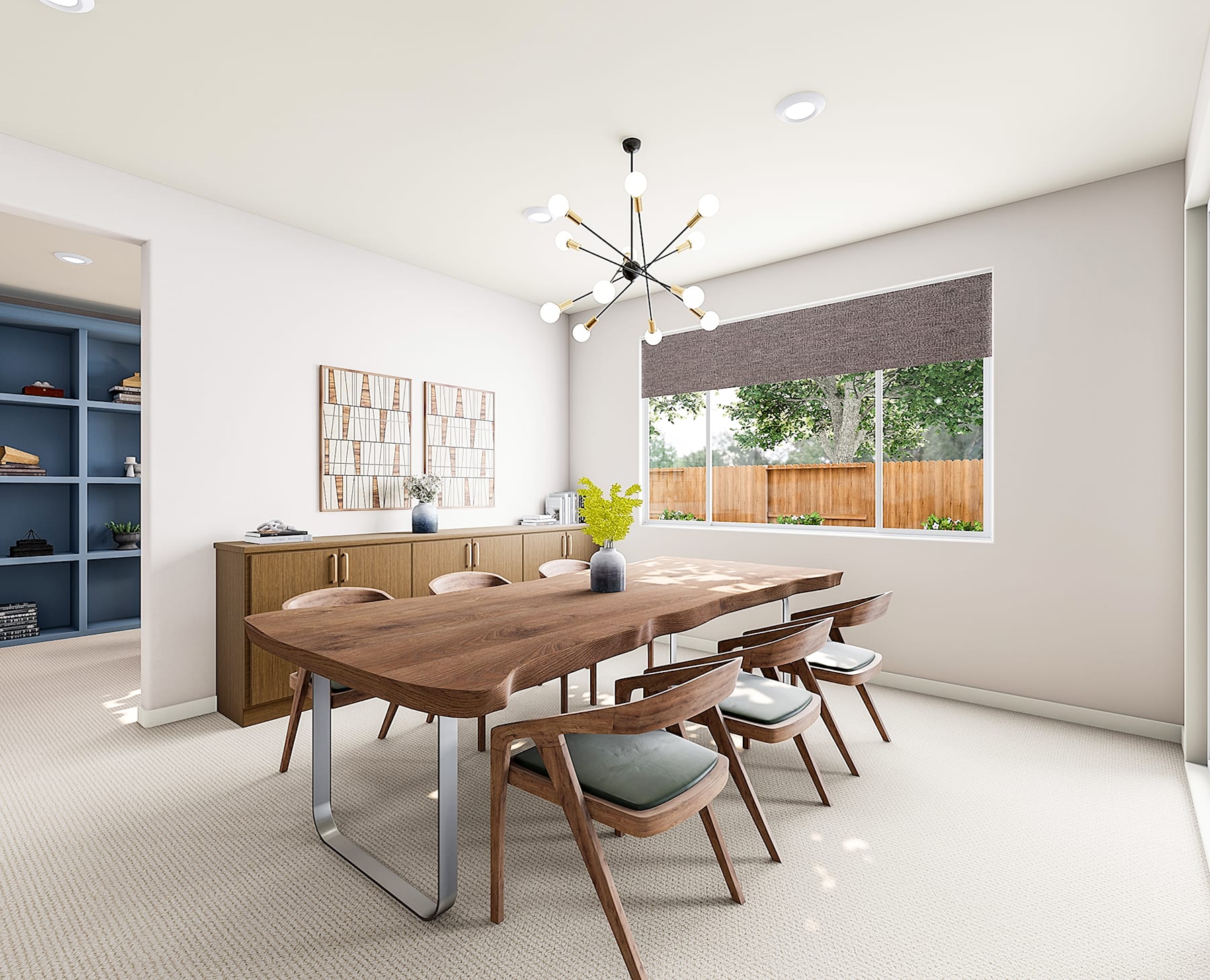 A modern and minimalist dining room with a large wooden table, chairs, and a chandelier hanging overhead, surrounded by a neutral-colored wall and a view of the outdoors through a window.