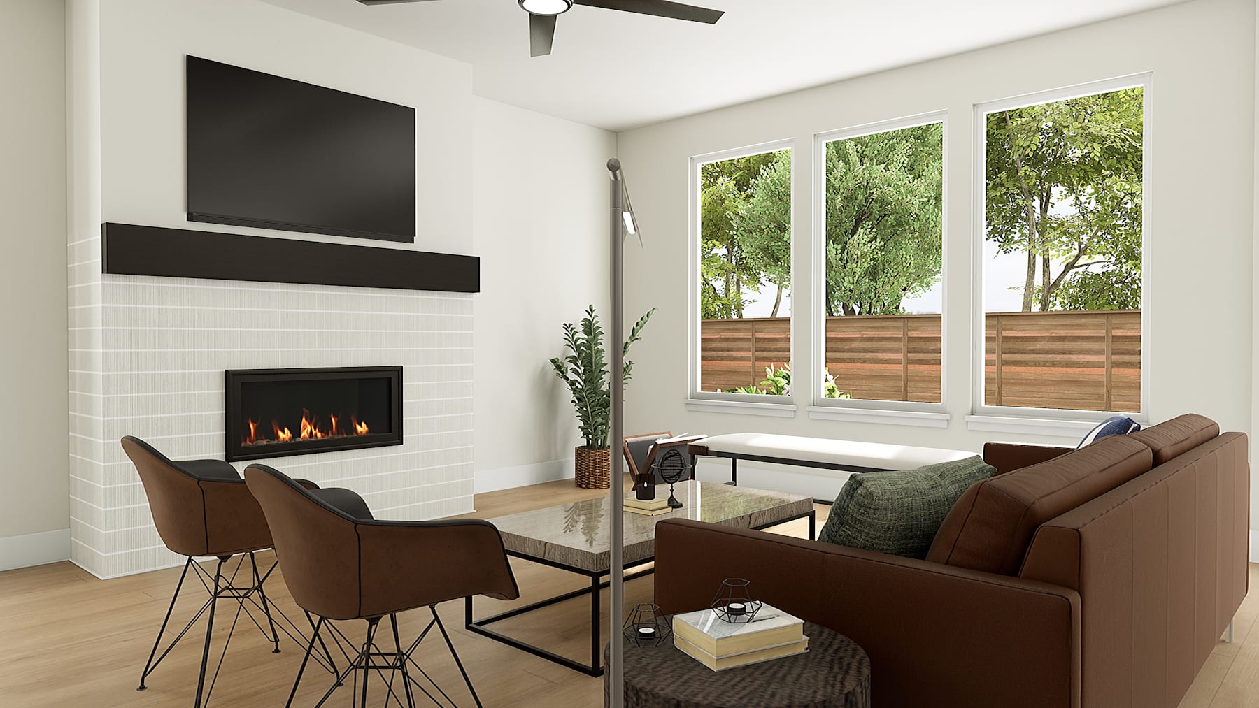 A cozy and modern living room with a fireplace, large windows overlooking a lush outdoor area, and comfortable brown leather furniture.