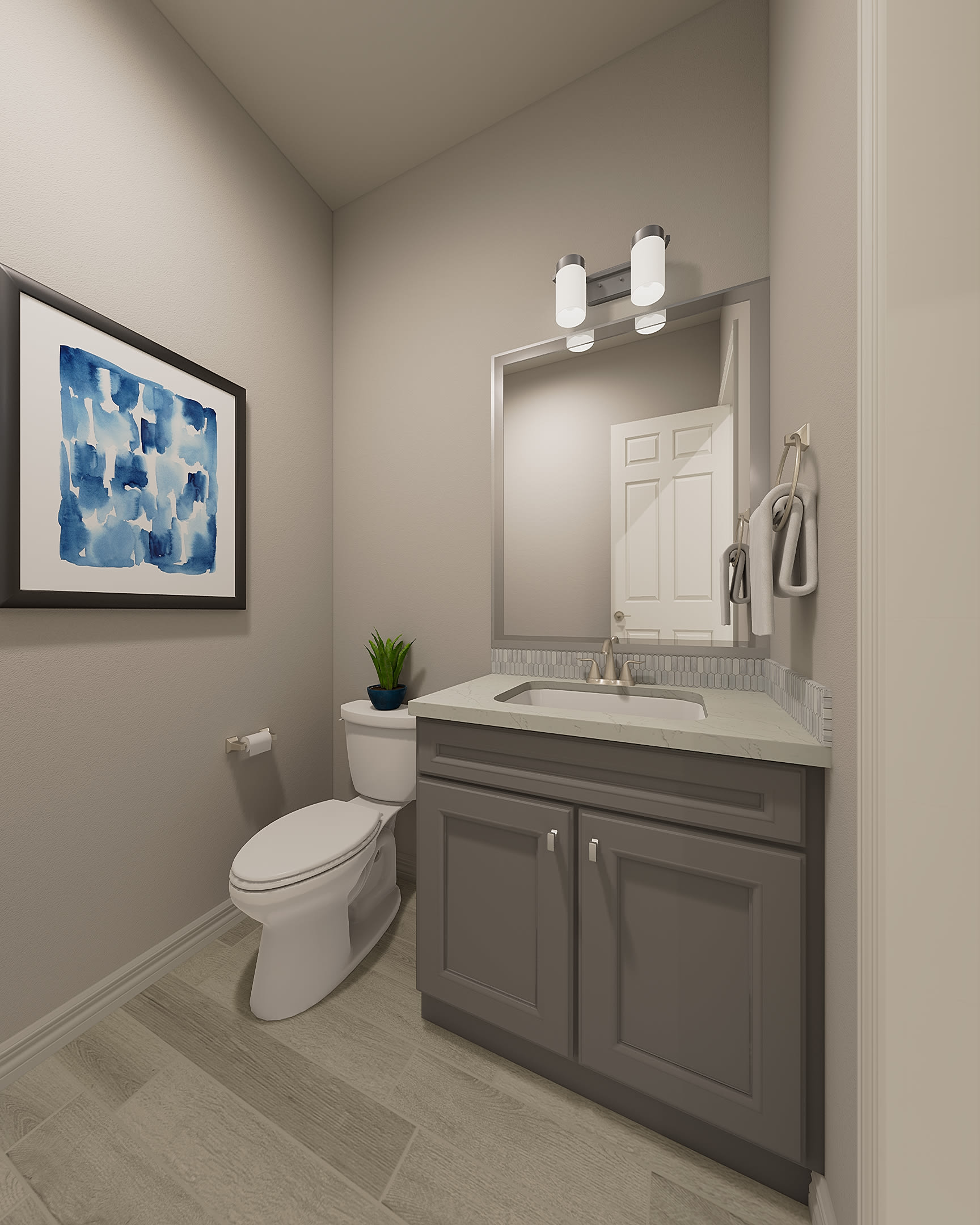 A modern and minimalist bathroom with a gray vanity, white toilet, and a framed abstract artwork on the wall.