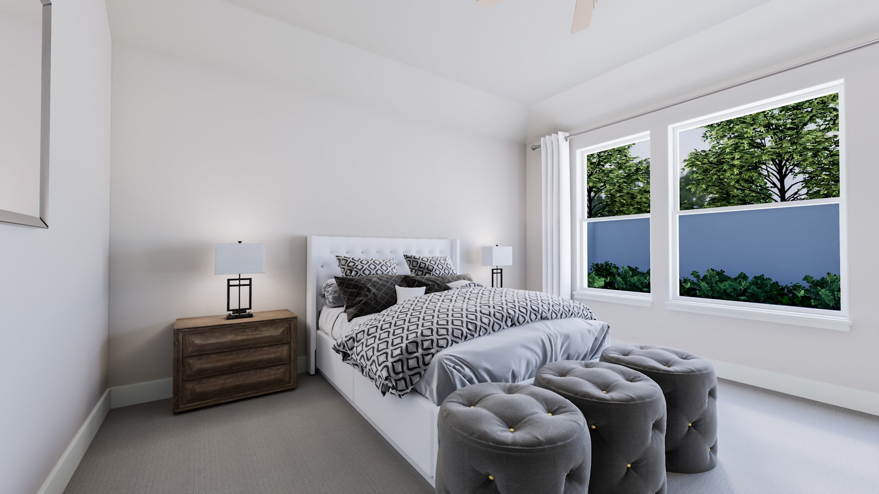 A cozy and modern bedroom with a large window overlooking a lush, green landscape, featuring a patterned bedding set and plush gray ottomans.