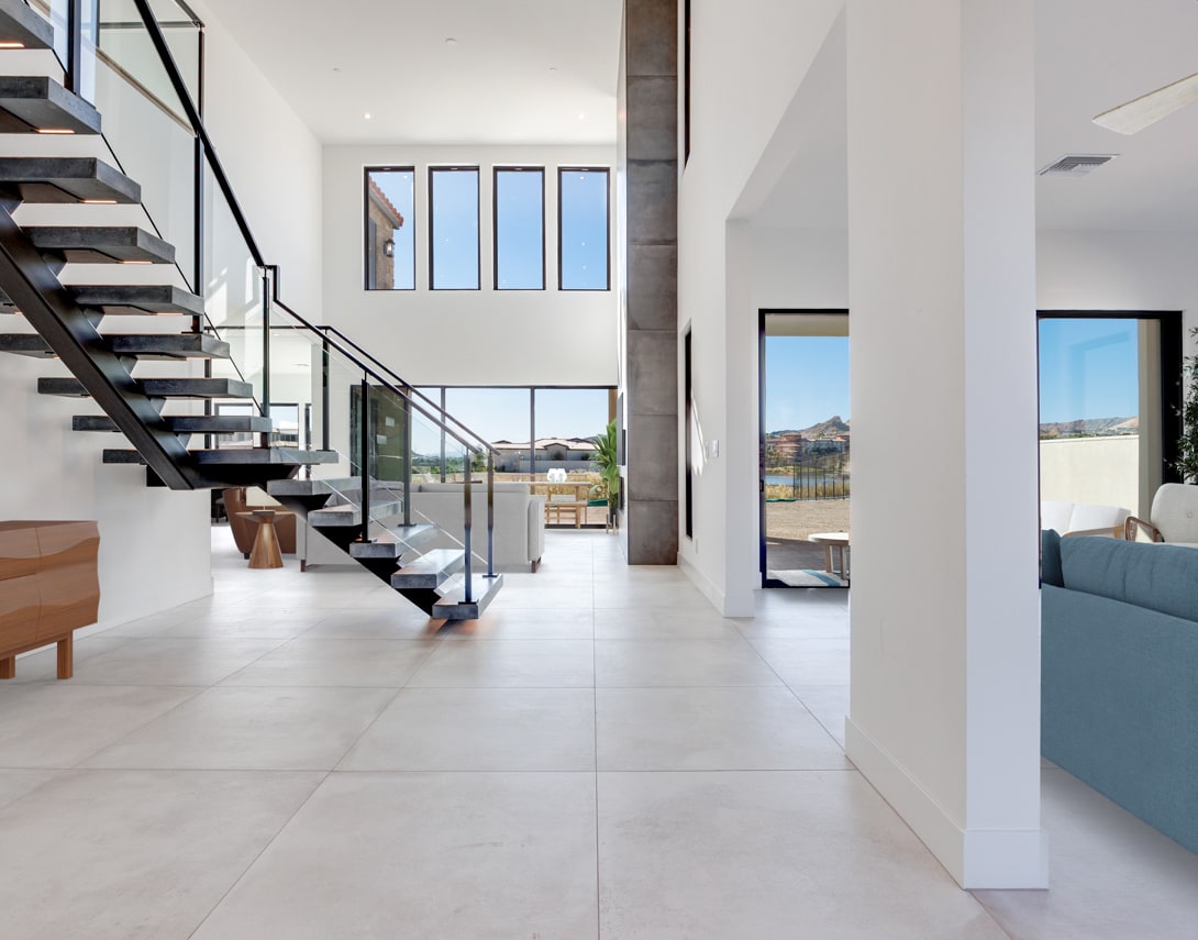 A modern, open-concept interior with a sleek staircase, large windows, and a minimalist design aesthetic, providing a bright and airy atmosphere.