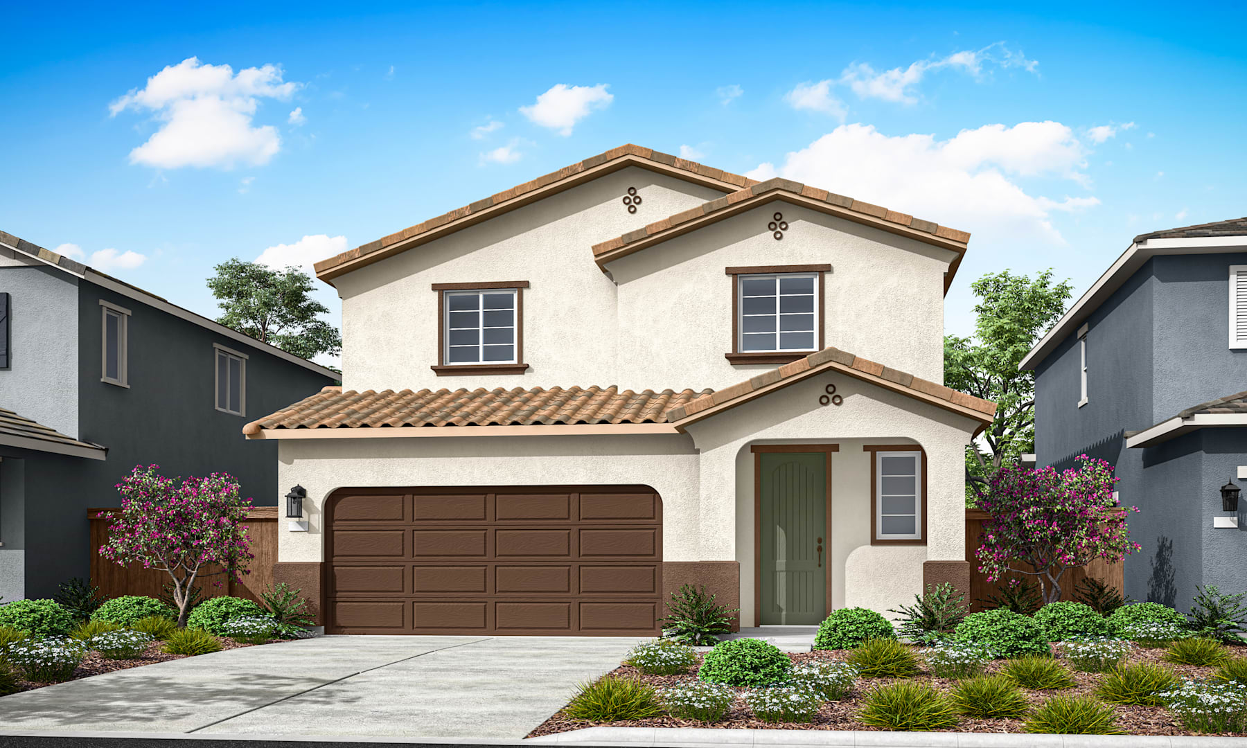 A two-story beige house with a brown tiled roof, a garage door, and a well-landscaped front yard with flowering plants and shrubs against a clear blue sky with fluffy white clouds.