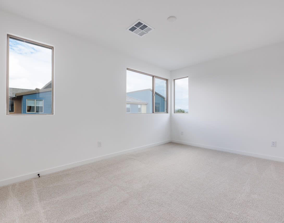 A spacious, bright room with large windows, a clean and minimalist interior design, and a smooth, light-colored floor.