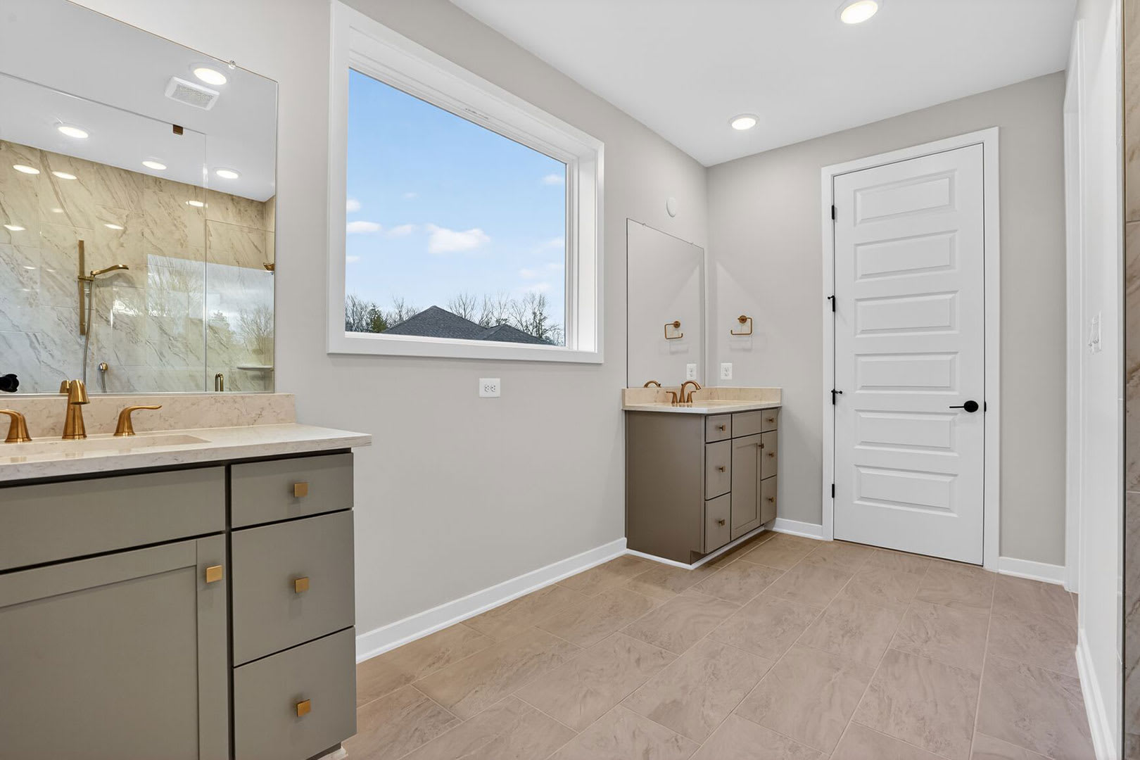 A modern and bright bathroom with a vanity, mirror, and a window overlooking the exterior.