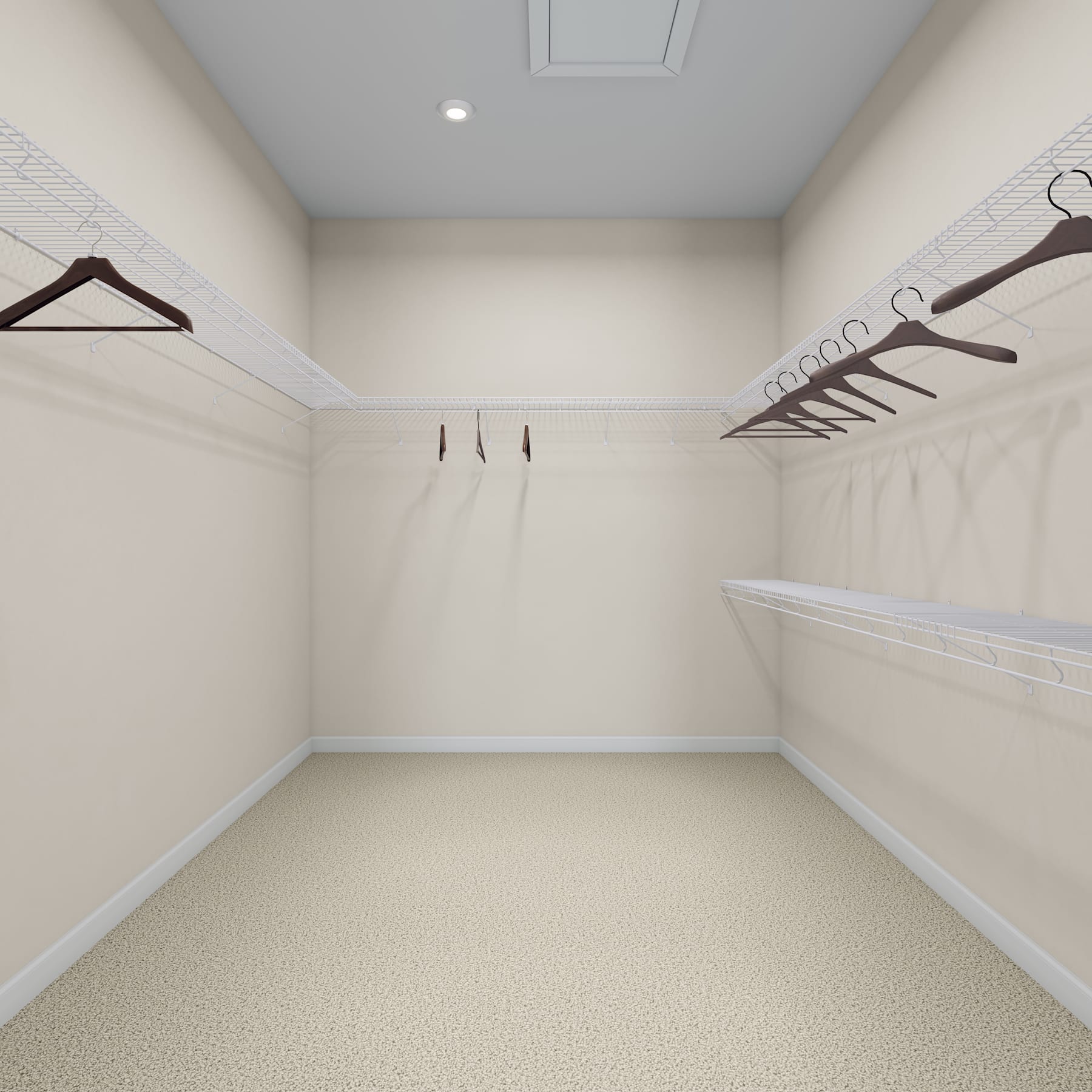A spacious and well-organized walk-in closet with white walls, wooden hangers, and a carpeted floor.