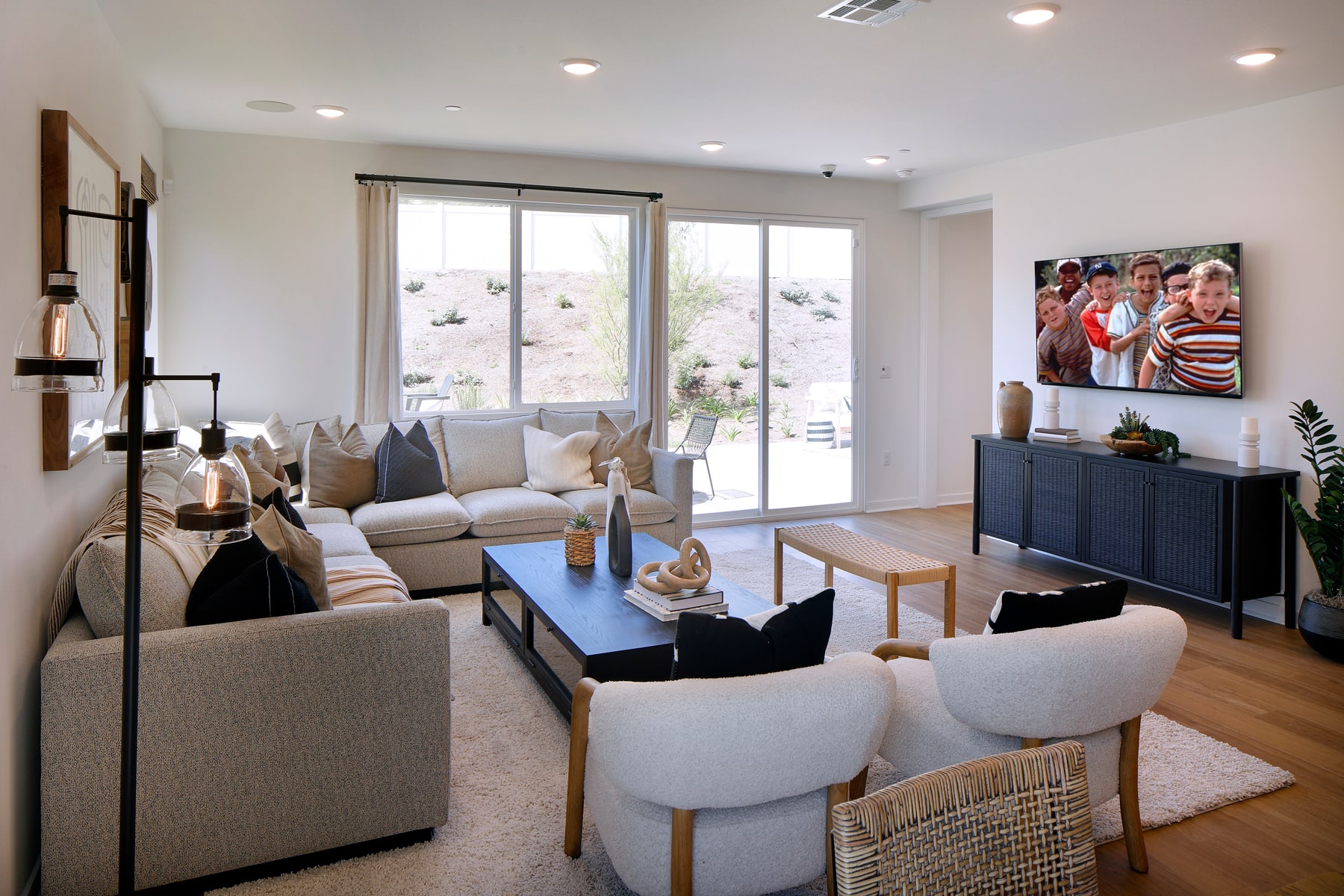 A cozy and modern living room with comfortable seating, a large window overlooking a scenic outdoor area, and various decorative elements creating a warm and inviting atmosphere.