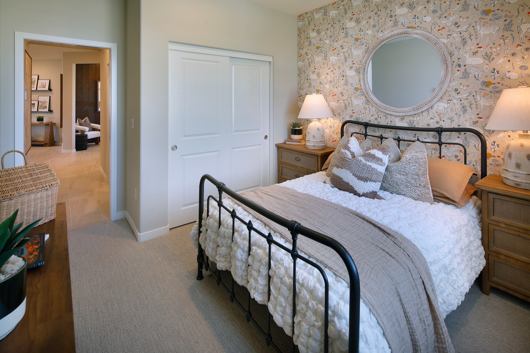 A cozy and inviting bedroom with a metal bed frame, floral wallpaper, and various decorative elements creating a warm and charming atmosphere.