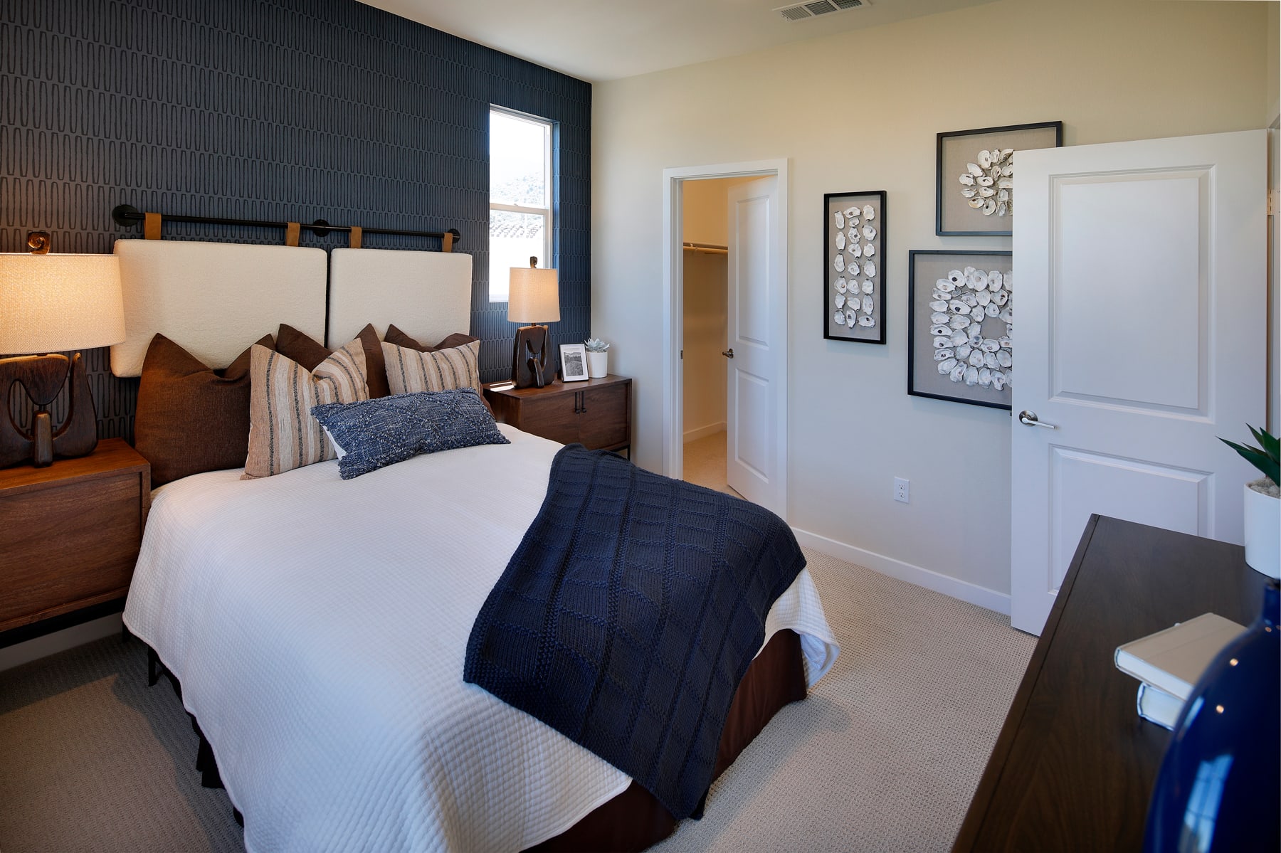 A cozy and well-decorated bedroom with a wooden headboard, plush bedding, and various decorative elements on the walls.