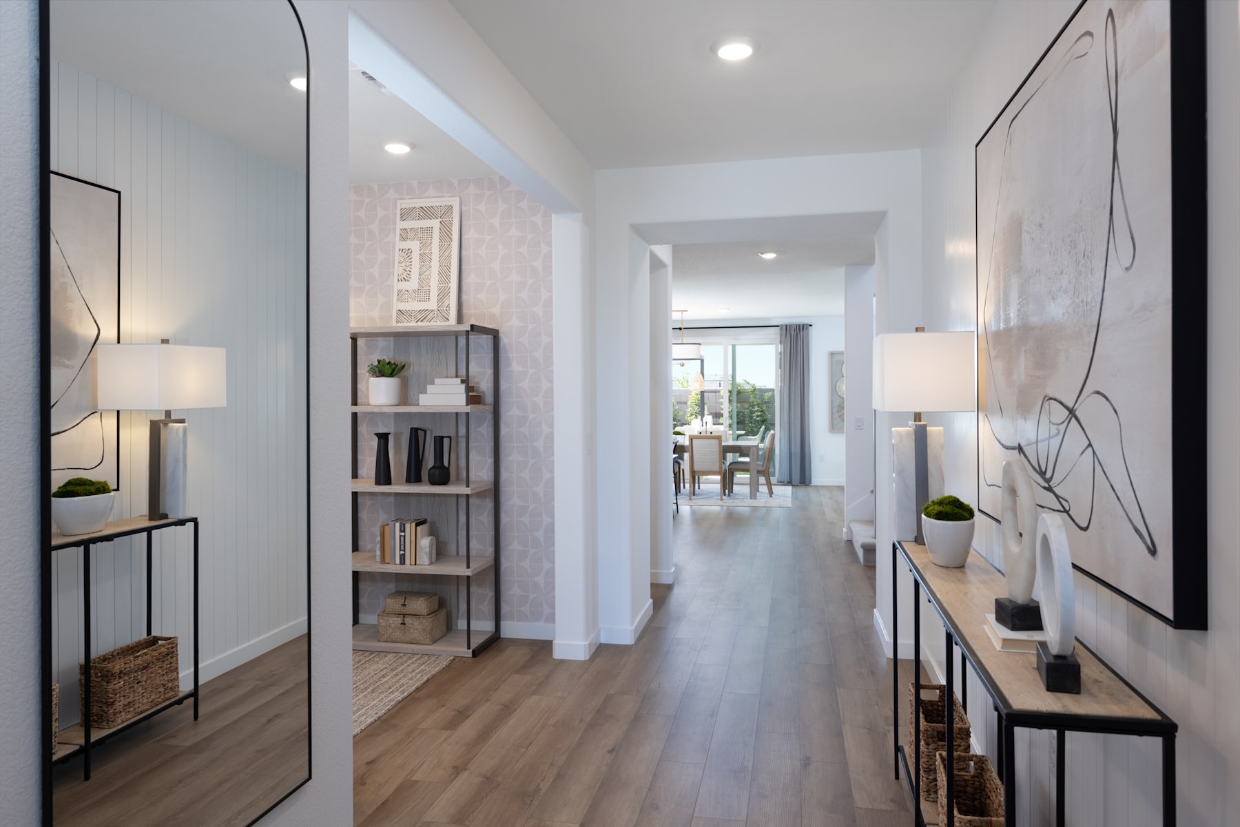 A bright, modern hallway with white walls, wooden floors, and various decorative elements such as shelves, lamps, and artwork.