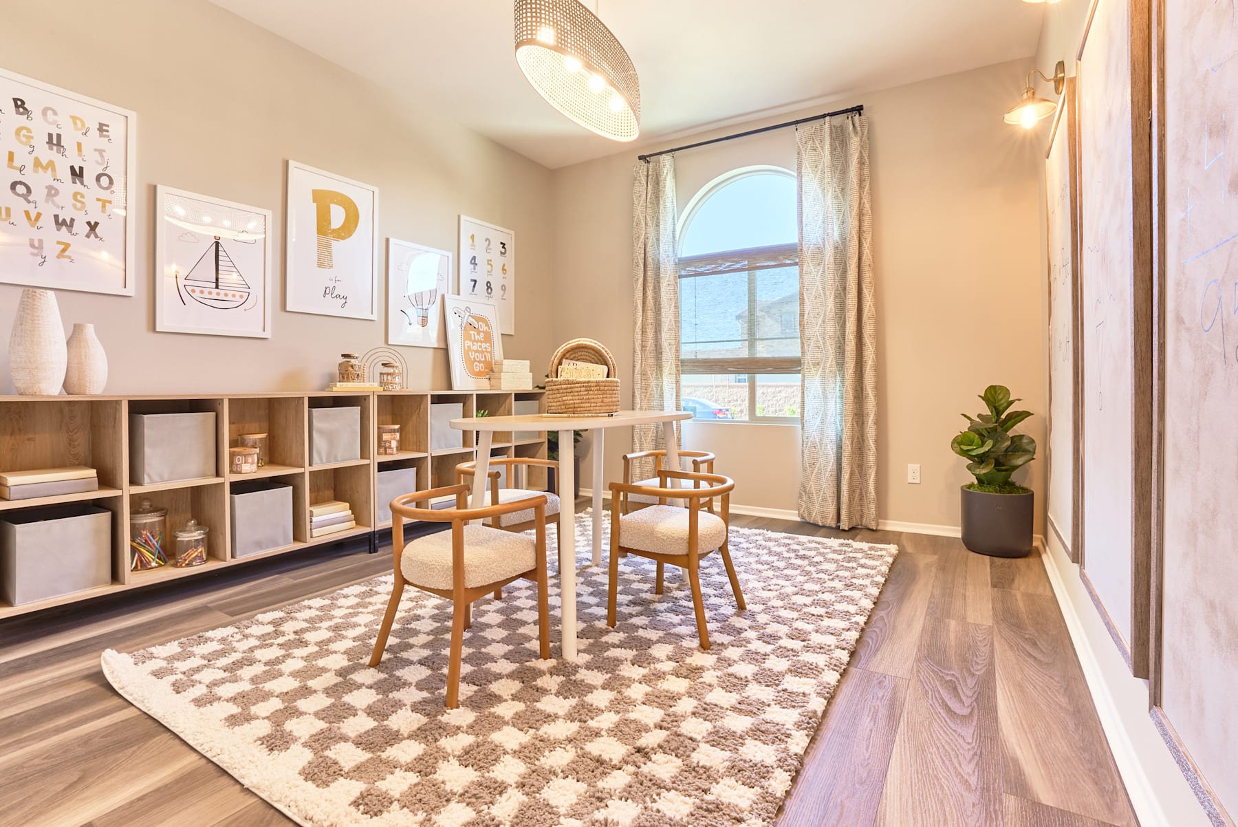 A cozy and well-designed home office space with wooden furniture, shelves displaying decorative items, and a patterned area rug on the hardwood floor.