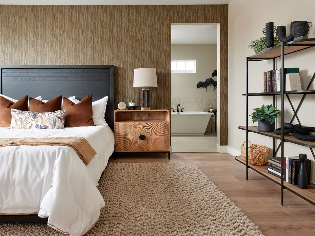 A cozy and inviting bedroom with a plush rug, a wooden nightstand, and a modern bathroom visible in the background, creating a harmonious and relaxing atmosphere.