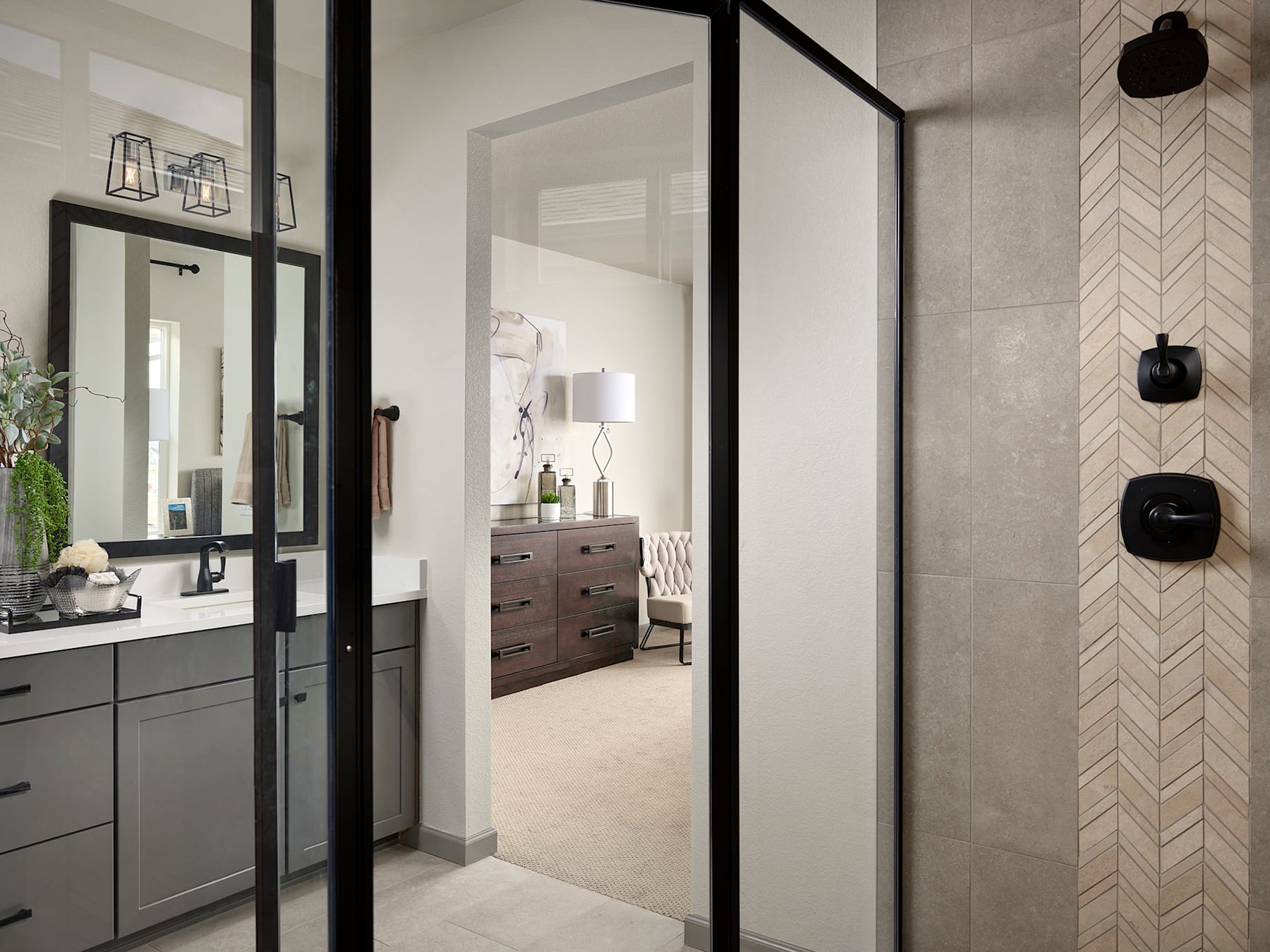 A modern bathroom with a vanity, mirrors, and a doorway leading to an adjacent room, featuring a sleek and minimalist design aesthetic.