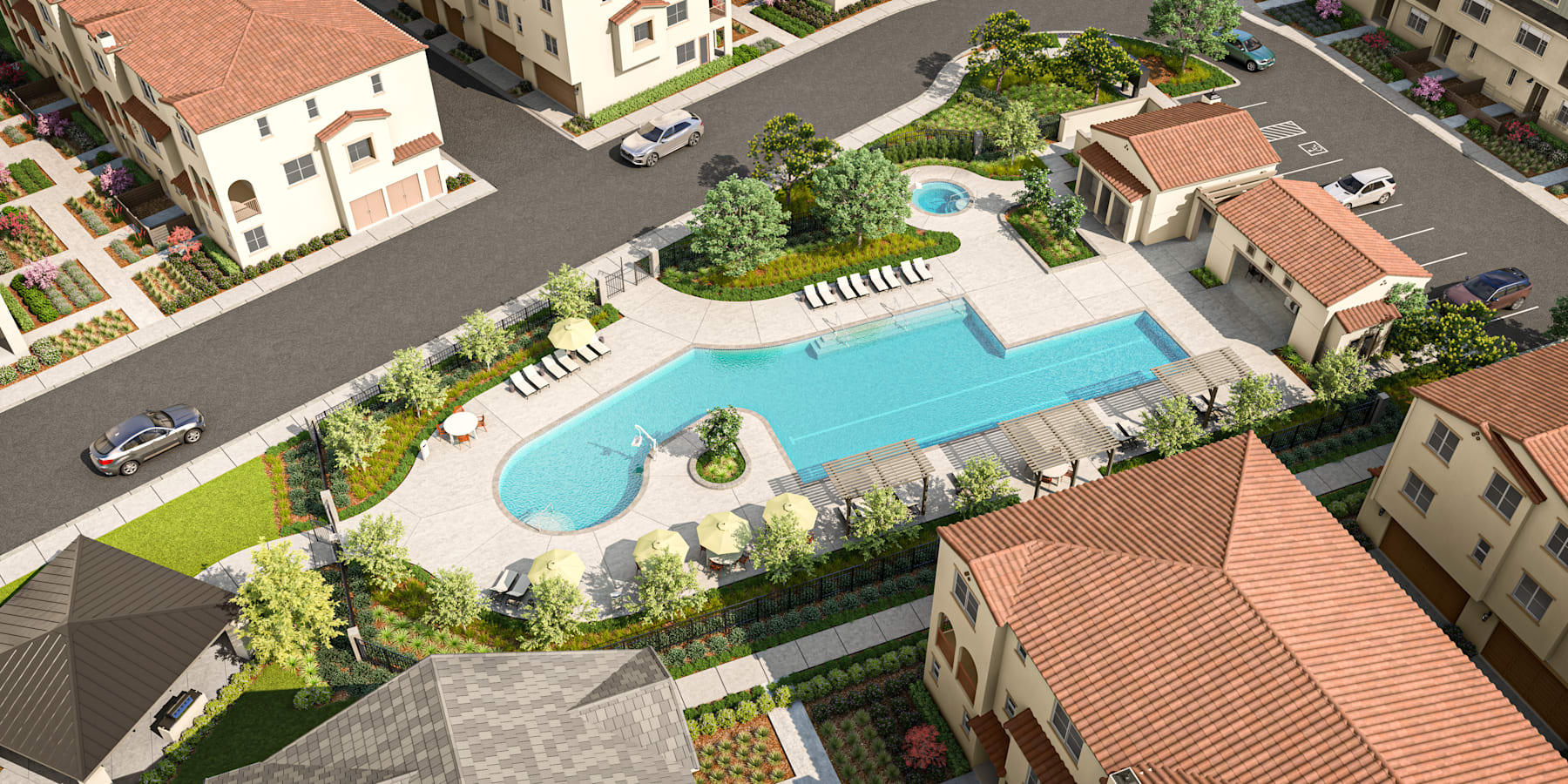 An aerial view of a residential complex with a swimming pool surrounded by lush greenery, landscaped gardens, and various buildings with red-tiled roofs.