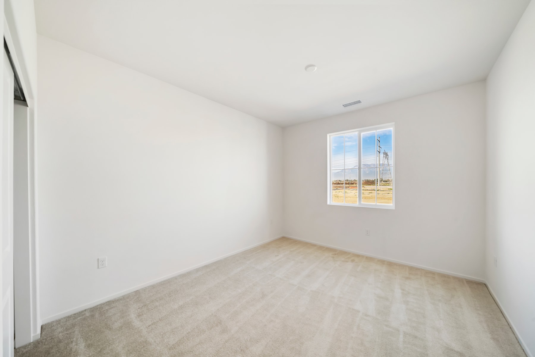A simple, minimalist room with a large window overlooking an outdoor landscape.