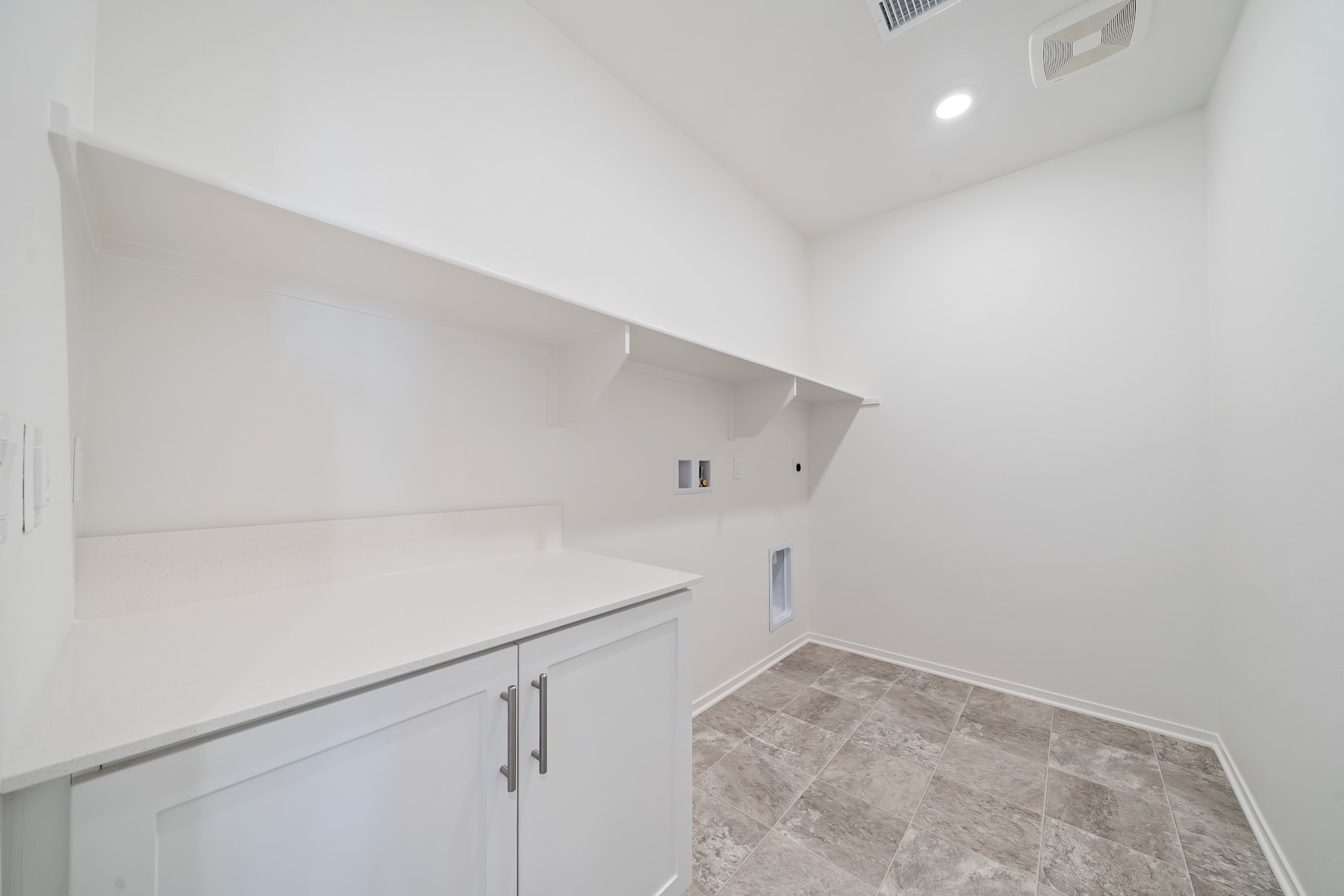 A white-walled room with built-in cabinets and a tiled floor, creating a clean and minimalist interior design.