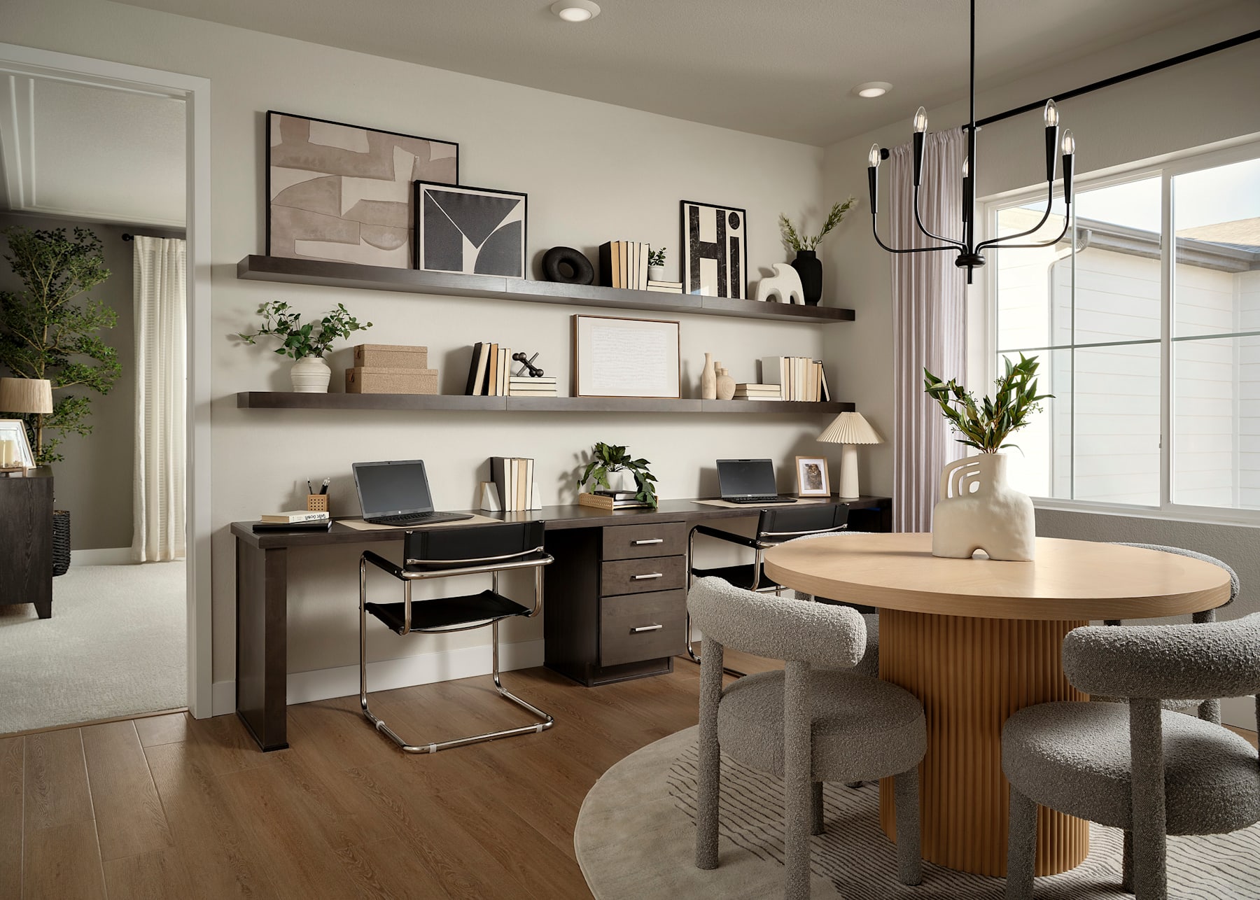 A cozy and well-designed home office space with a wooden table, shelves displaying various decor items, and a comfortable seating area.