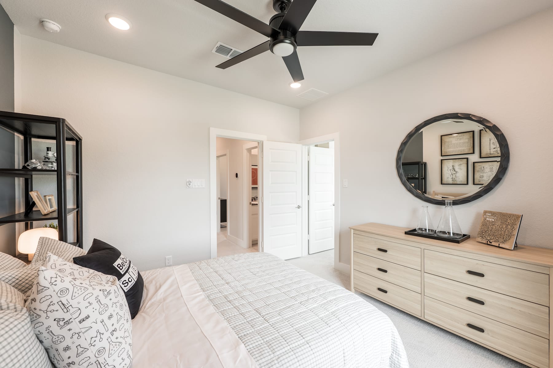 A cozy and well-furnished bedroom with a large bed, a dresser, and a round mirror on the wall, creating a warm and inviting atmosphere.