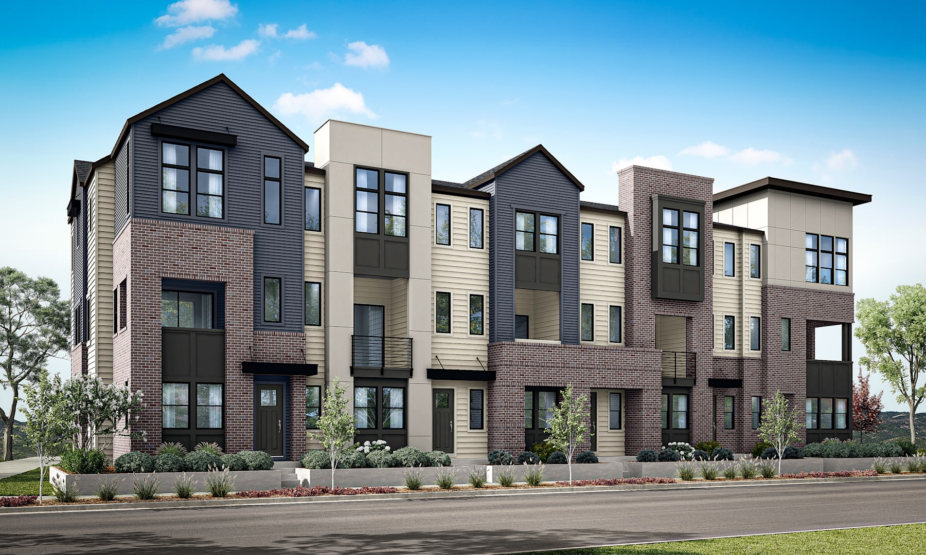 A row of modern, multi-story townhouses with a mix of brick and siding exterior, set against a backdrop of a clear blue sky with scattered clouds.