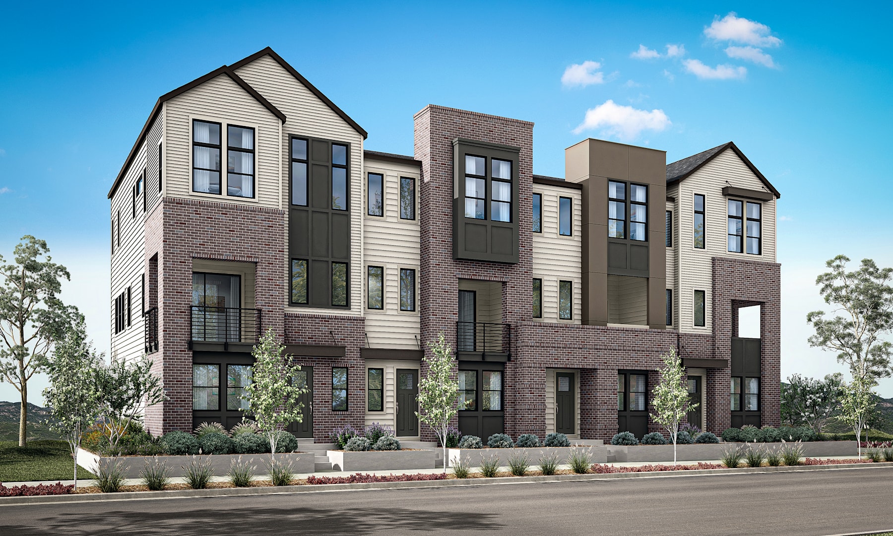 A modern multi-story residential building with a mix of brick and siding exterior, surrounded by trees and landscaping, set against a clear blue sky with fluffy white clouds.
