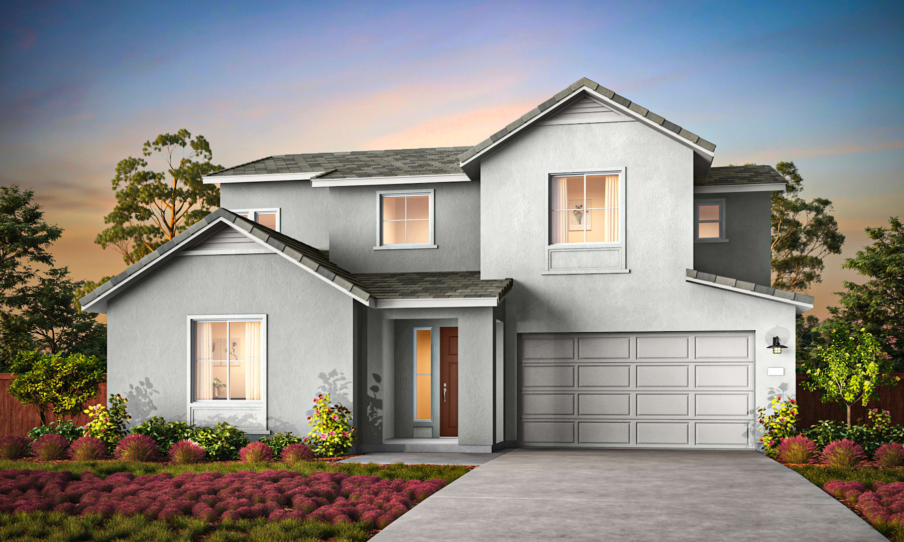 A two-story gray house with a garage door, surrounded by a lush garden and a colorful floral display in the foreground, set against a vibrant sunset sky.