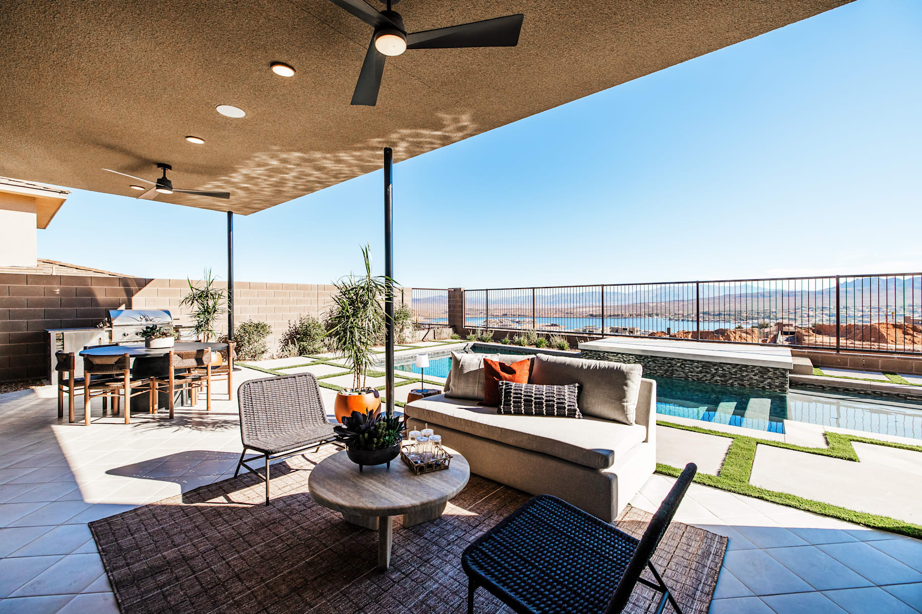 A cozy outdoor patio with a pool, comfortable seating, and a stunning view of the surrounding landscape.