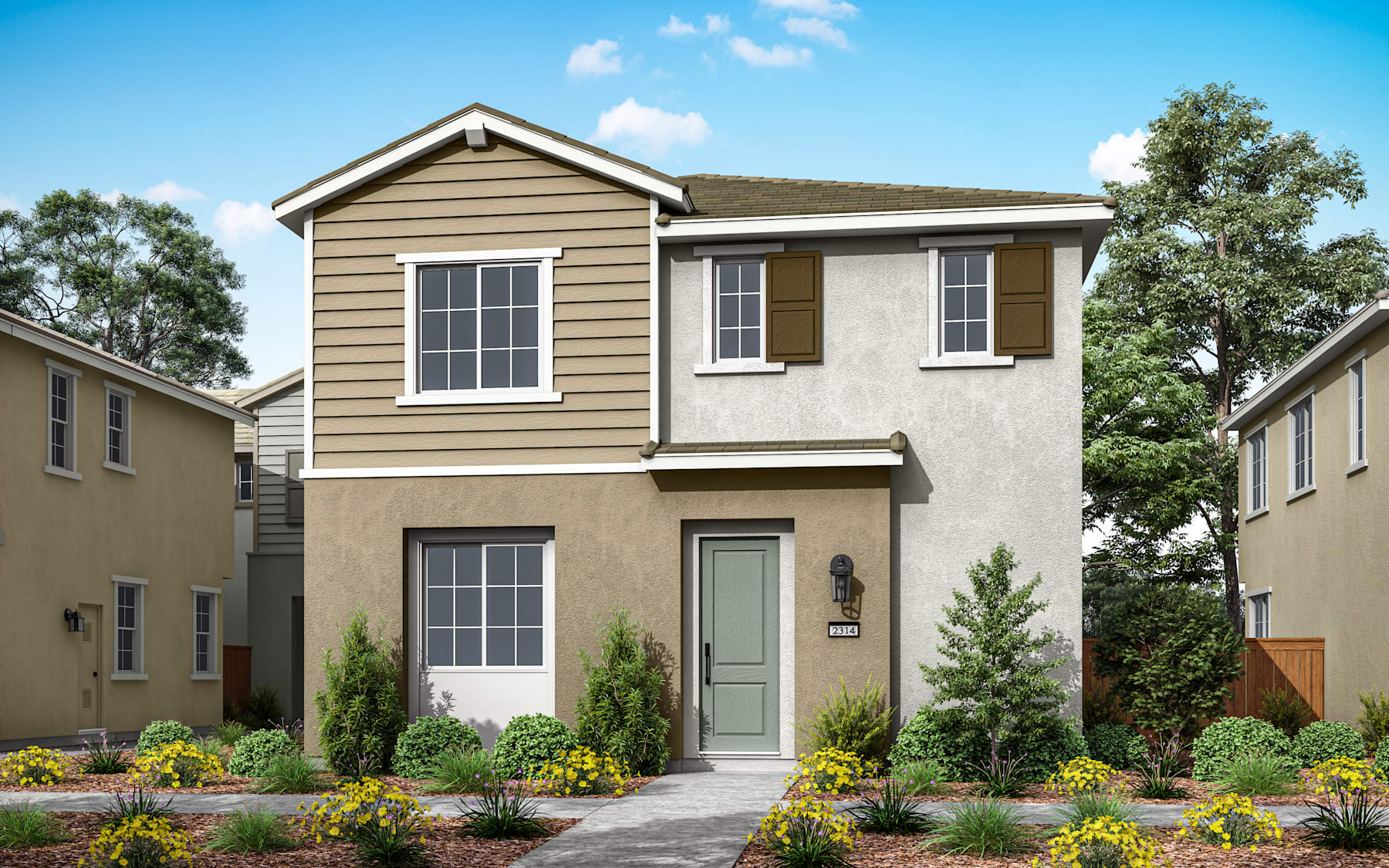 A two-story residential house with a tan exterior, a green front door, and a well-landscaped yard with trees and flowers in the foreground.