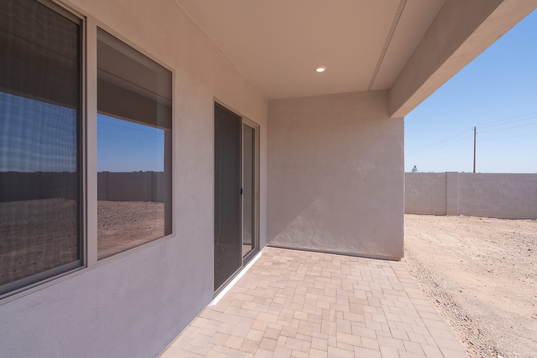 A spacious, well-lit hallway with large windows overlooking a barren, desert-like landscape in the background.