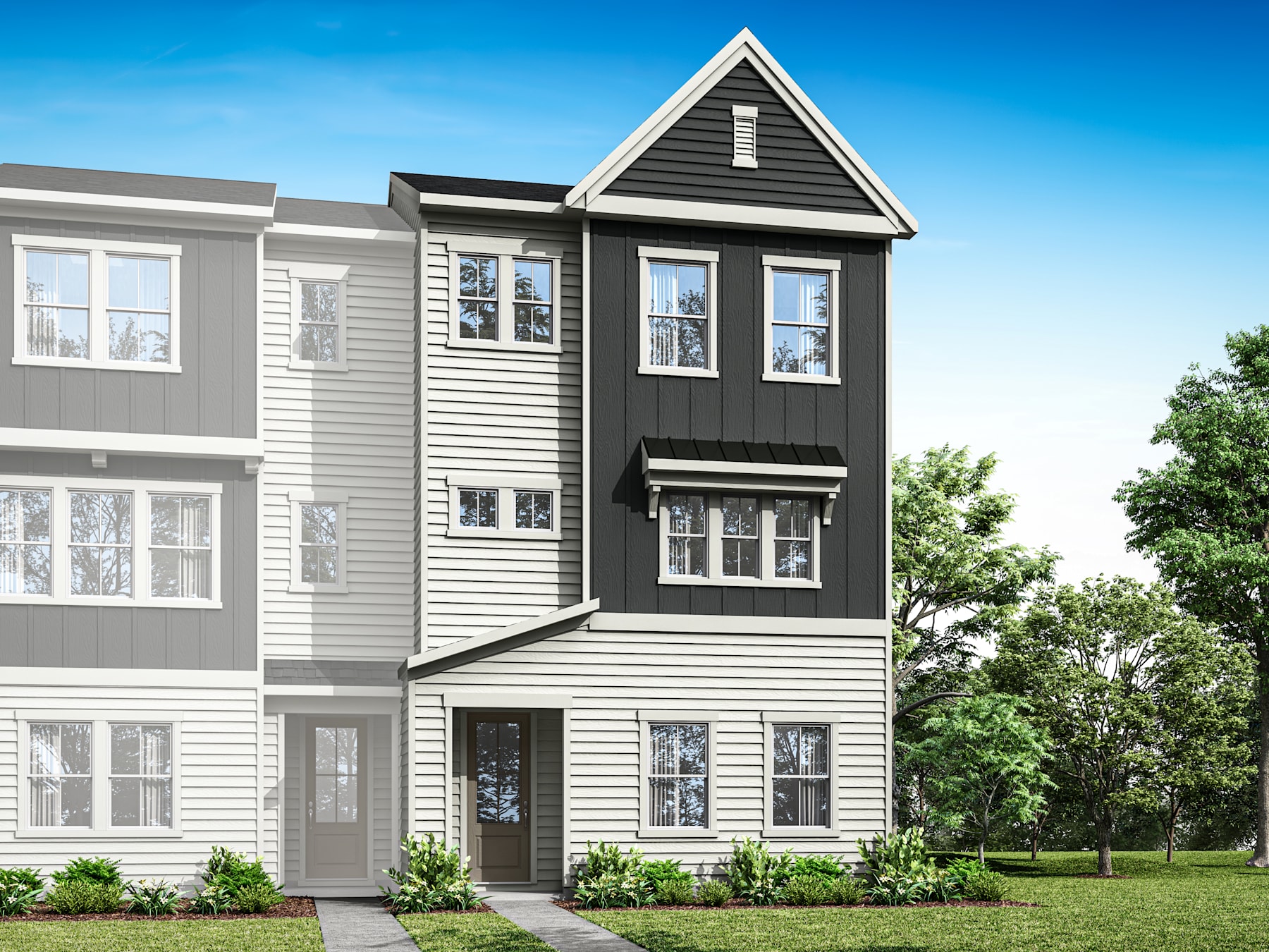 A modern, multi-story townhouse with gray siding and white trim, surrounded by lush greenery and a clear blue sky.