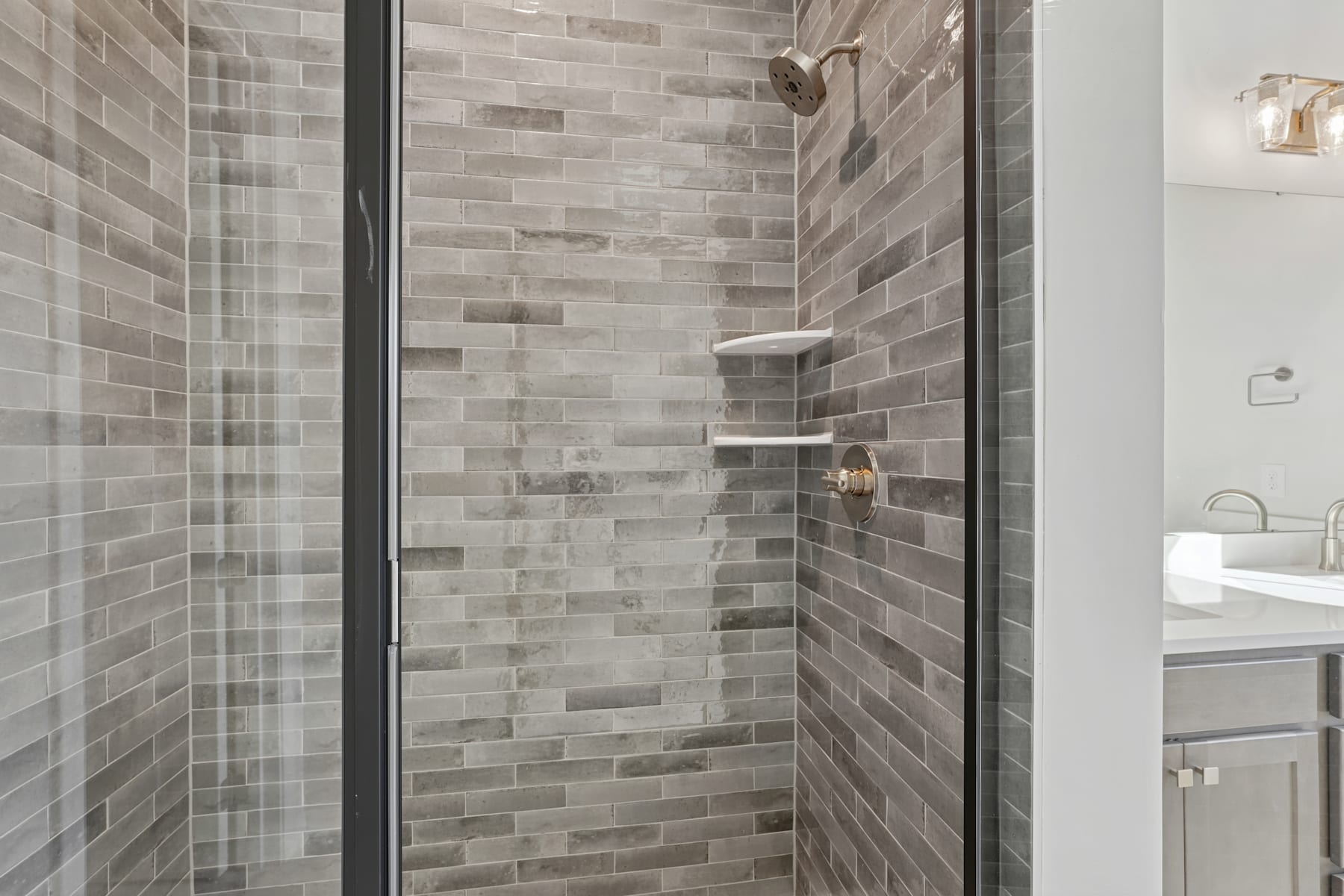 A modern, tiled shower enclosure with a glass door, featuring a sleek and minimalist design.